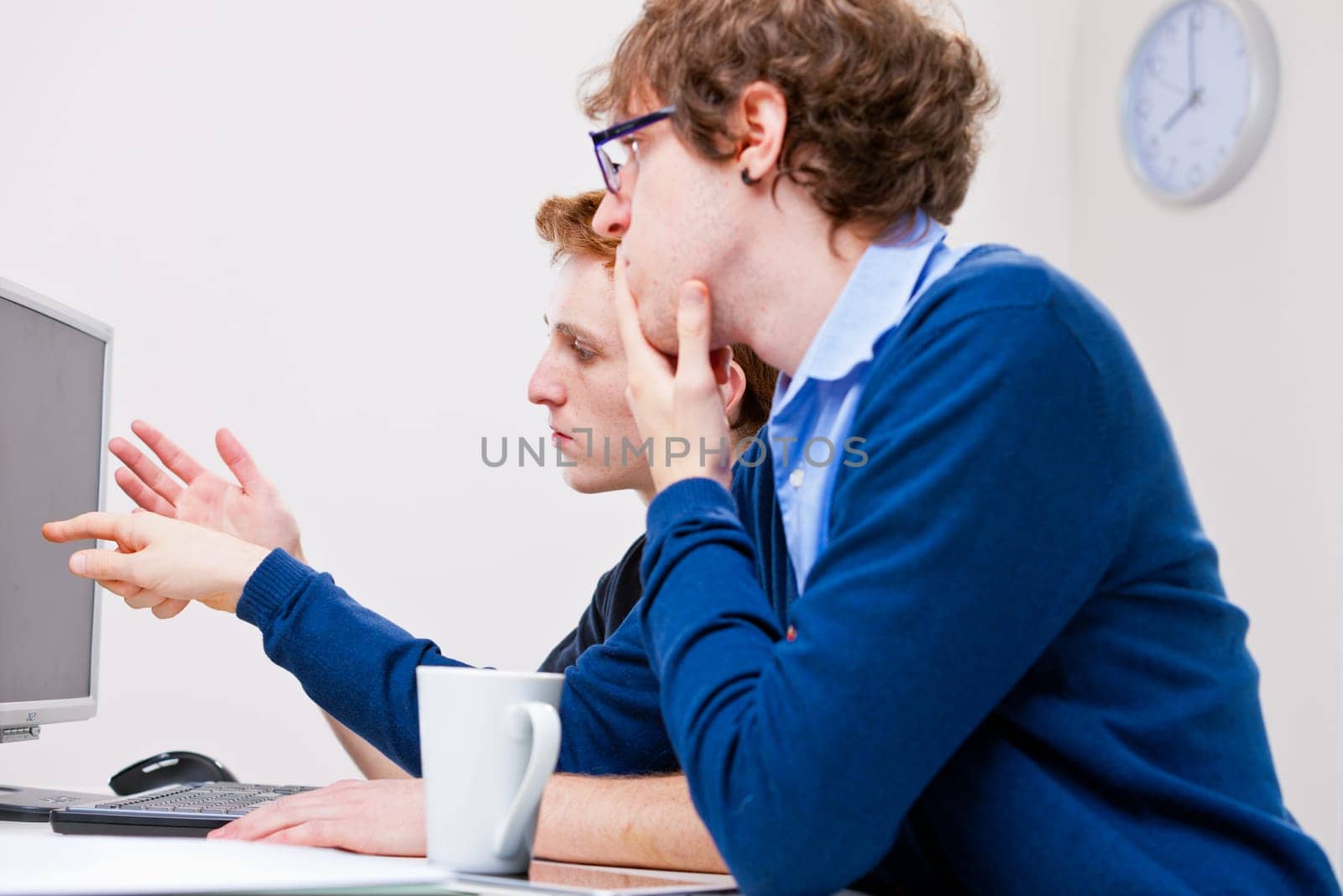 a couple of young employees in an office working together to achieve common goals