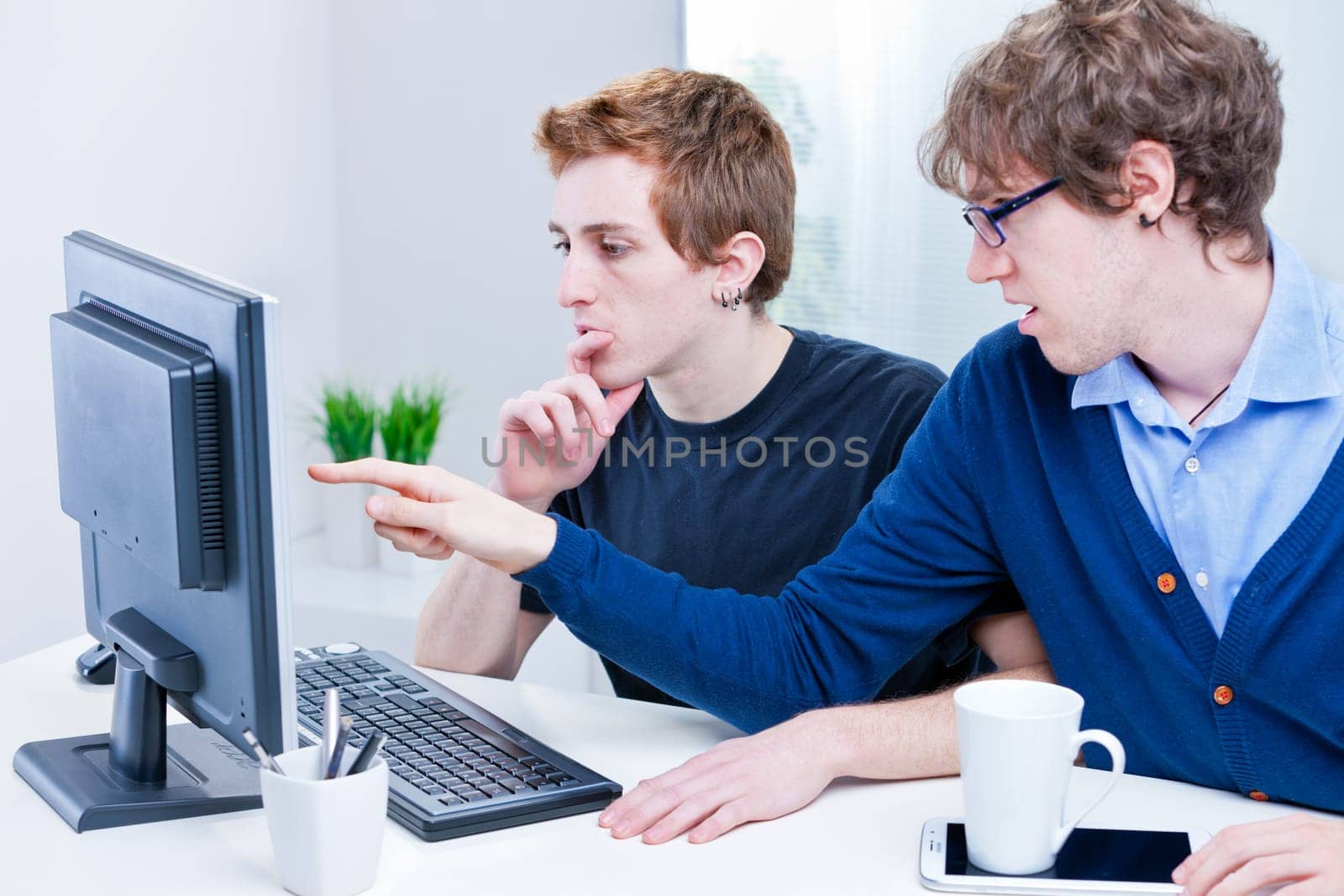 a couple of young employees in an office working together to achieve common goals