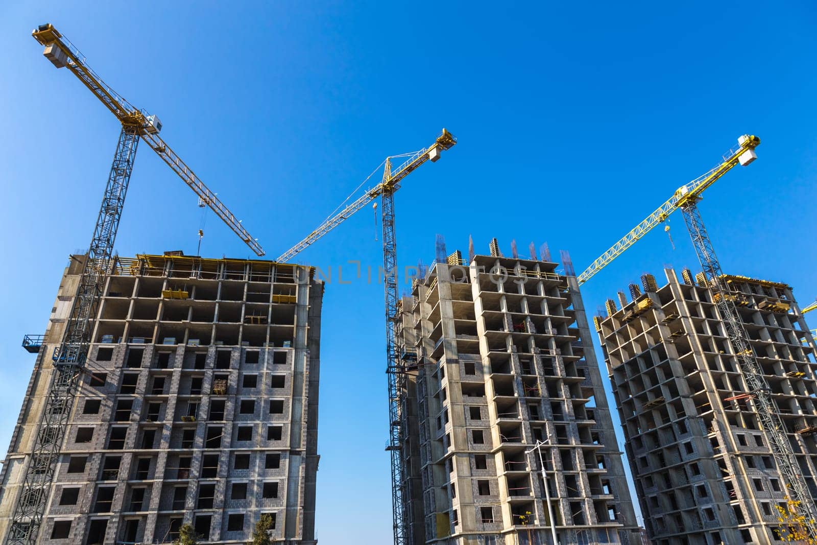 Construction cranes on building site on sky background