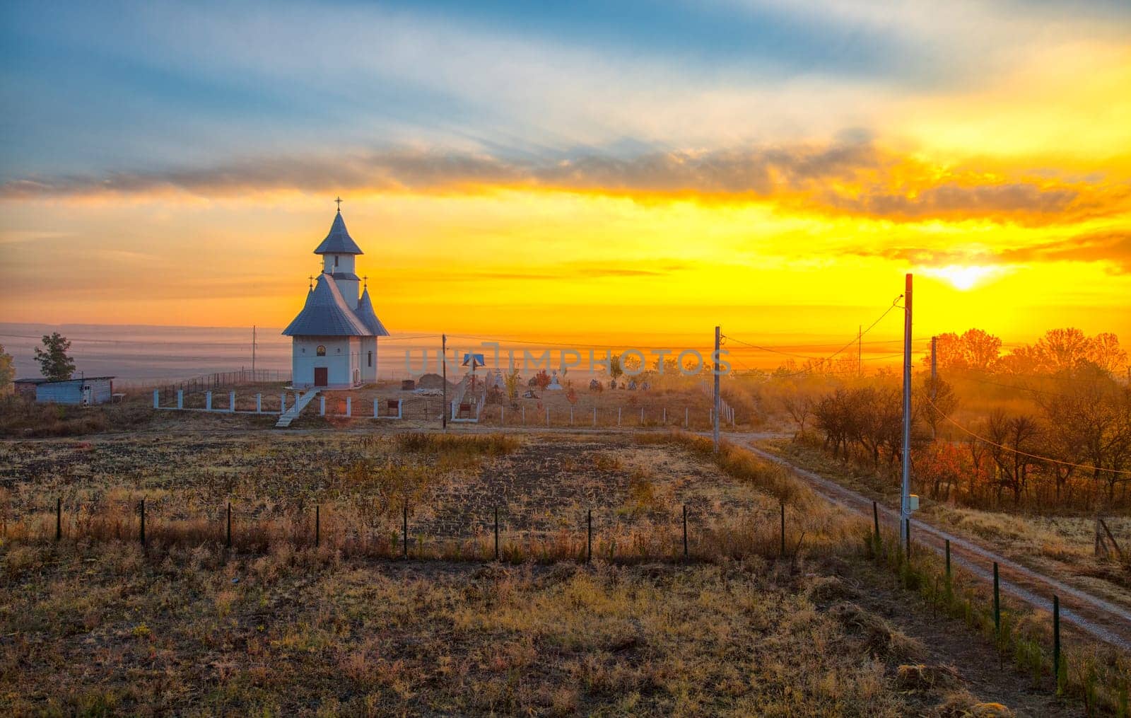 Landscape of the church in a small village in Romania at sunrise.