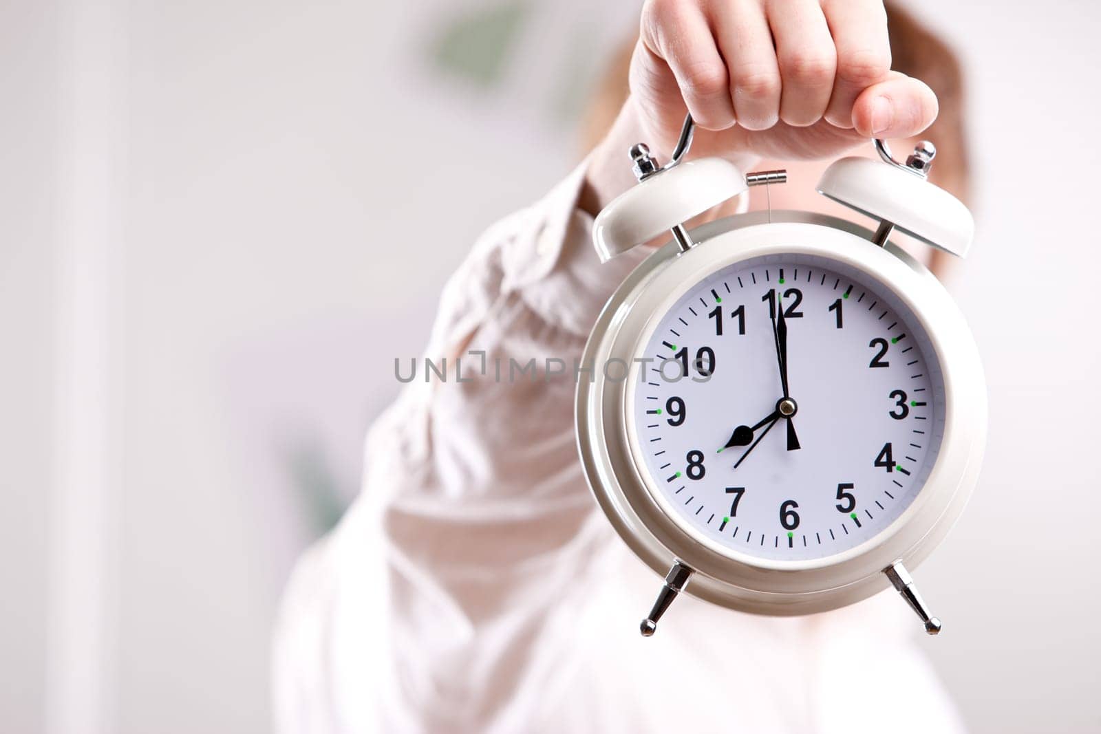 a red headed clerk showing off an alarm clock
