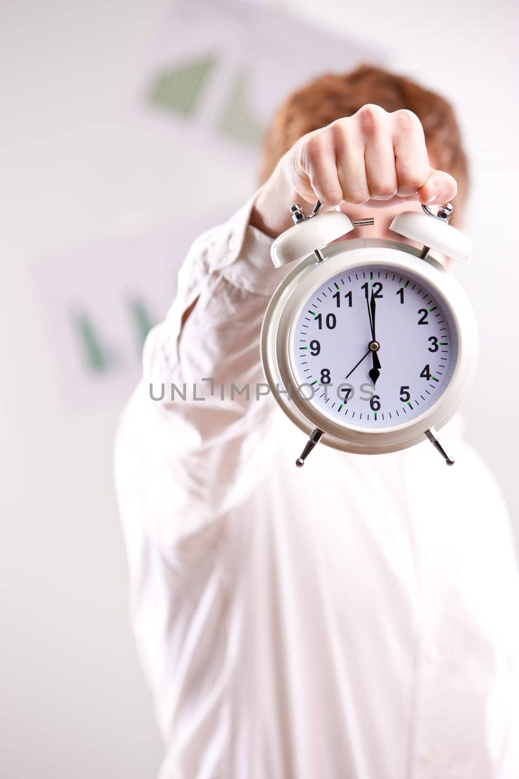 a red headed clerk showing off an alarm clock