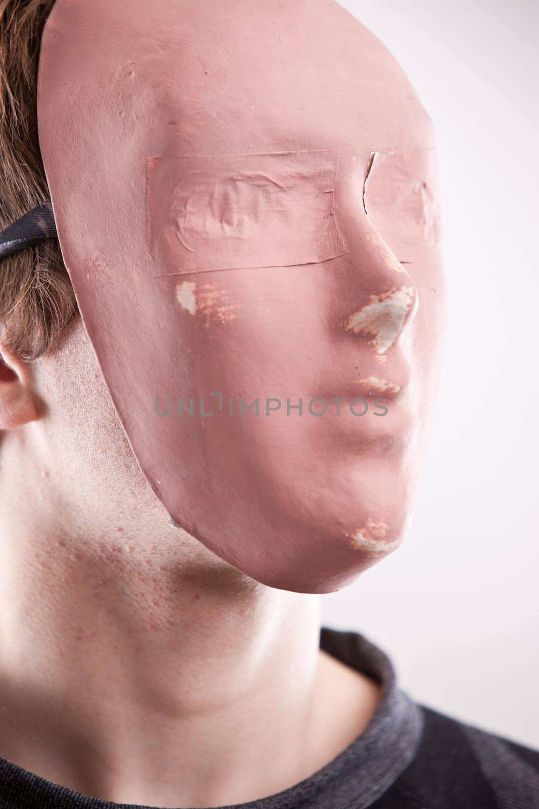a young man disguised behind a pink mask