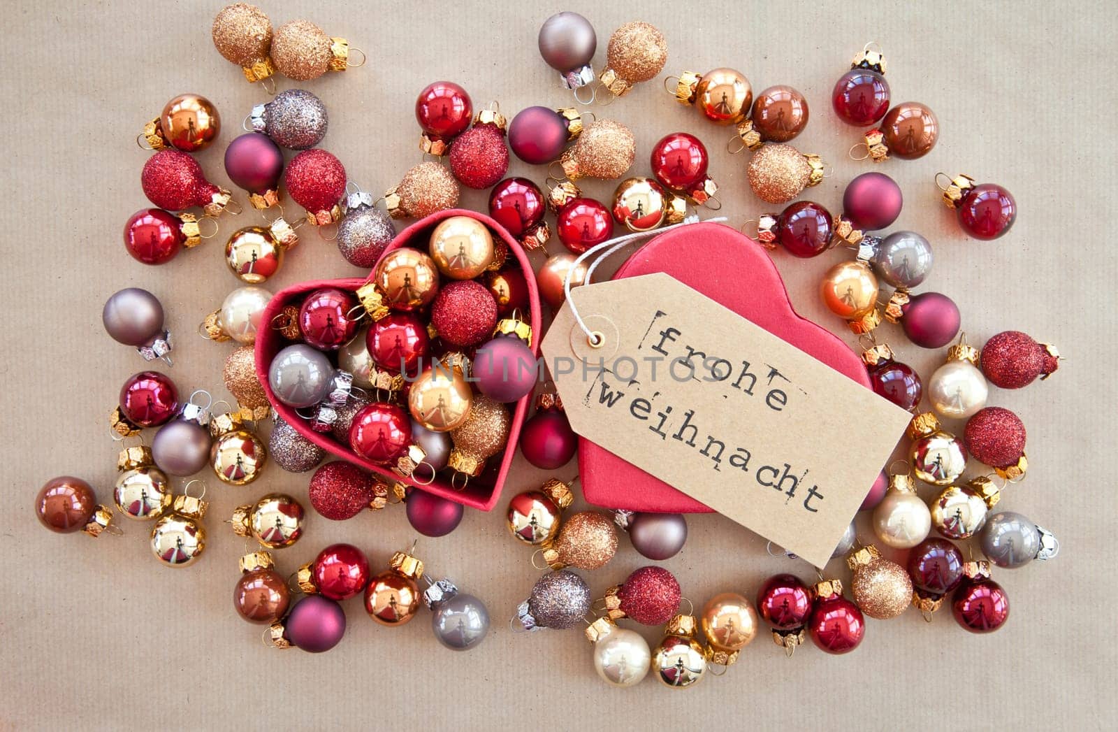 Red heart box with colorful Christmas tree balls on wrapping paper