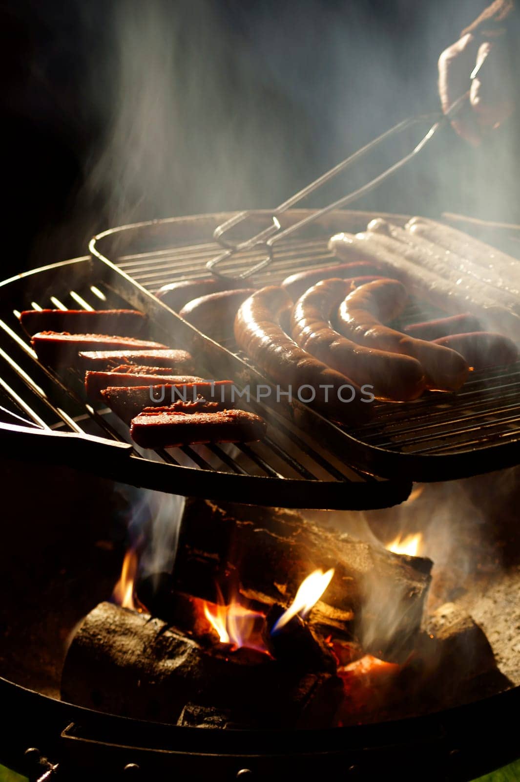 The photograph of a charcoal grill with sausages.