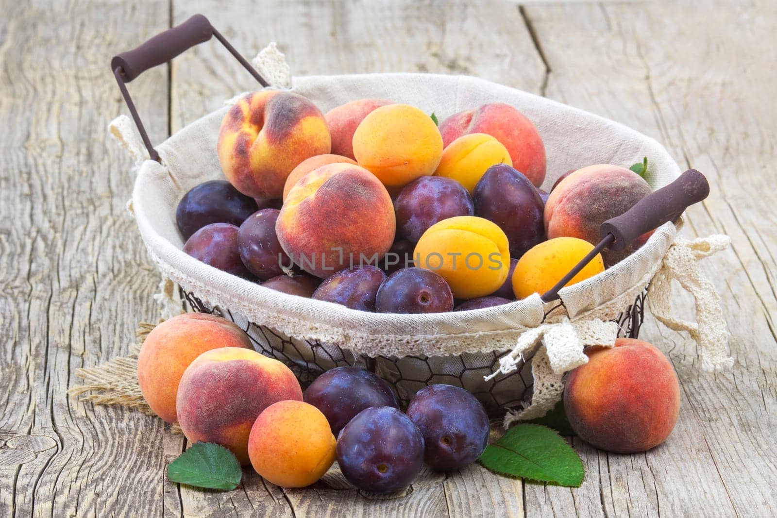 fresh fruits in a basket on wooden background