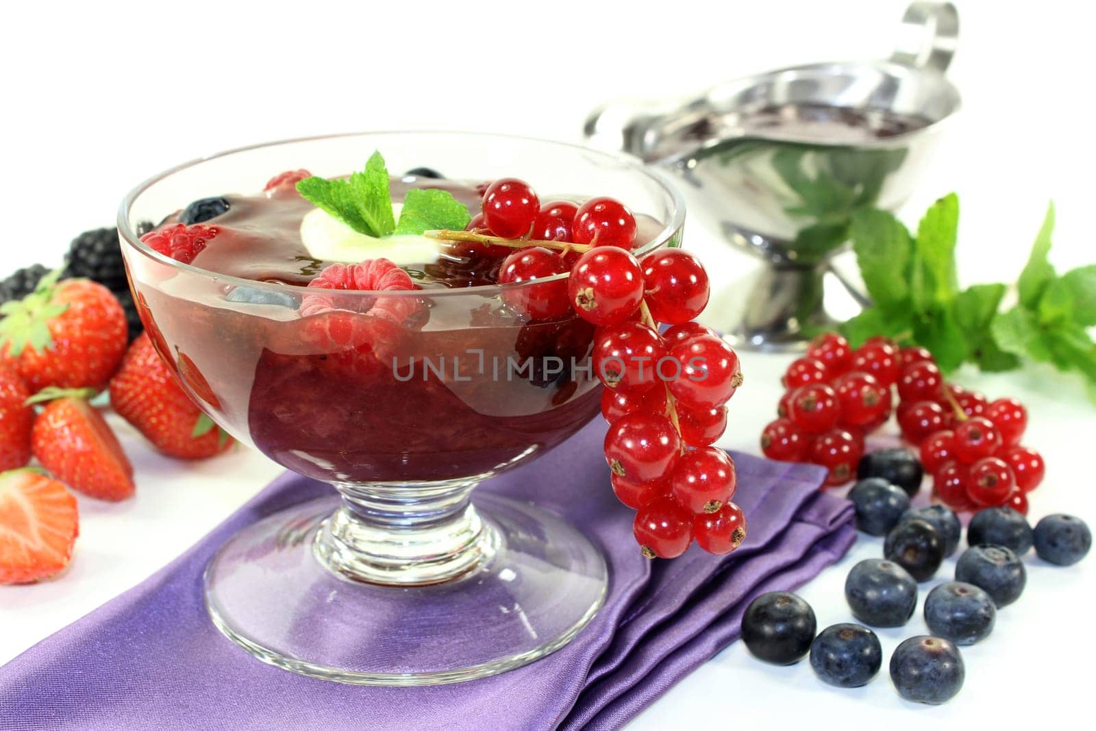 a glass with red grits,vanilla sauce and mint
