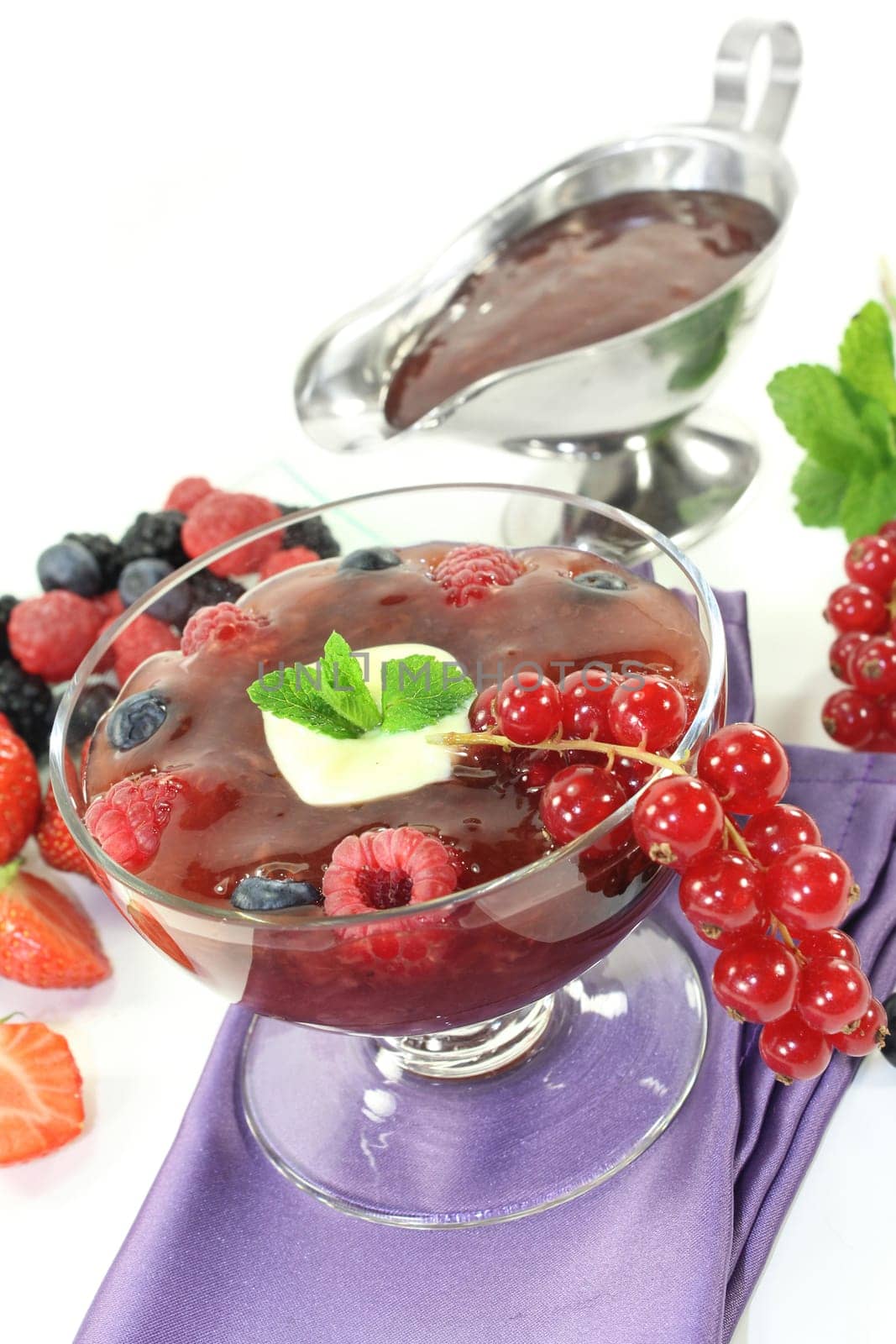 a glass with red grits,vanilla sauce and mint