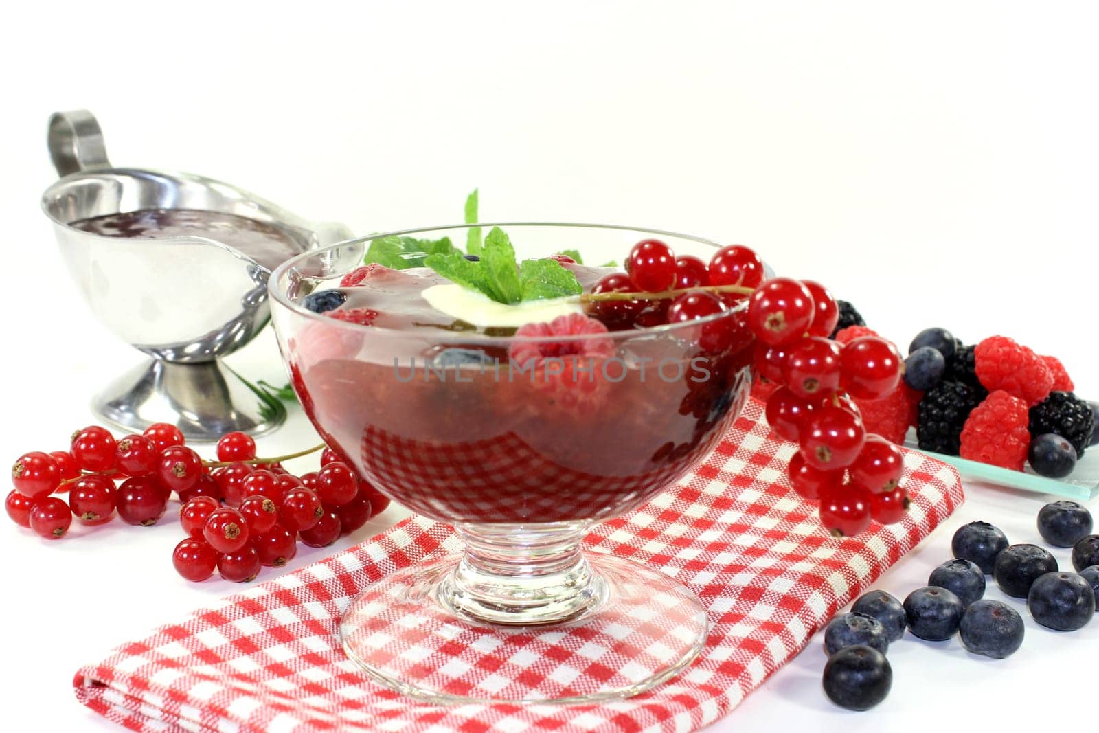 a glass with red grits,vanilla sauce and mint