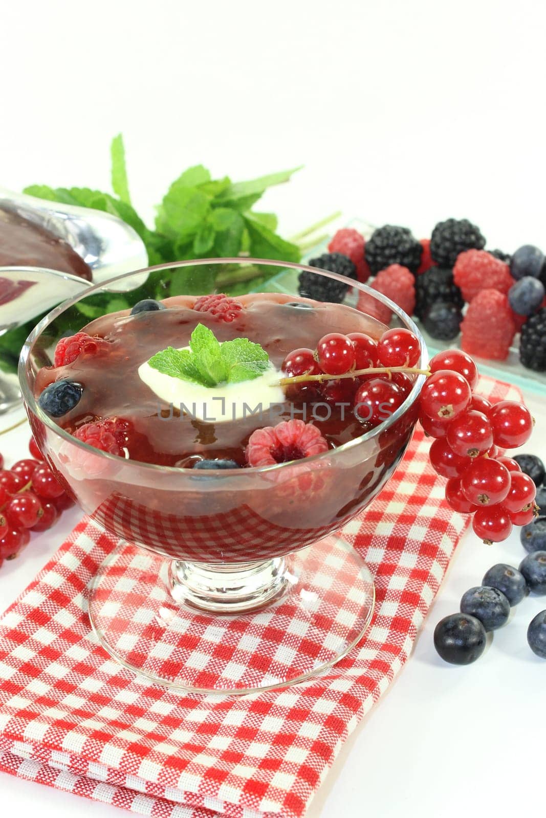 a glass with red grits,vanilla sauce and mint