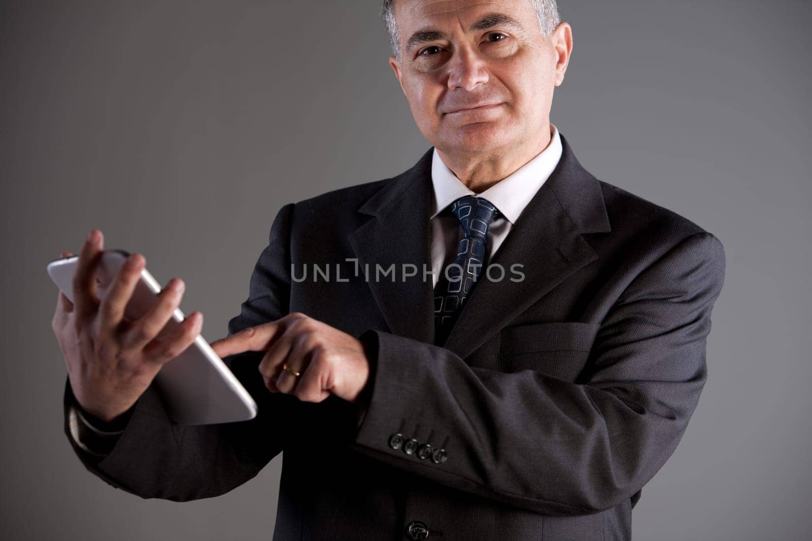 An old manager using successfully and with satisfaction a tablet