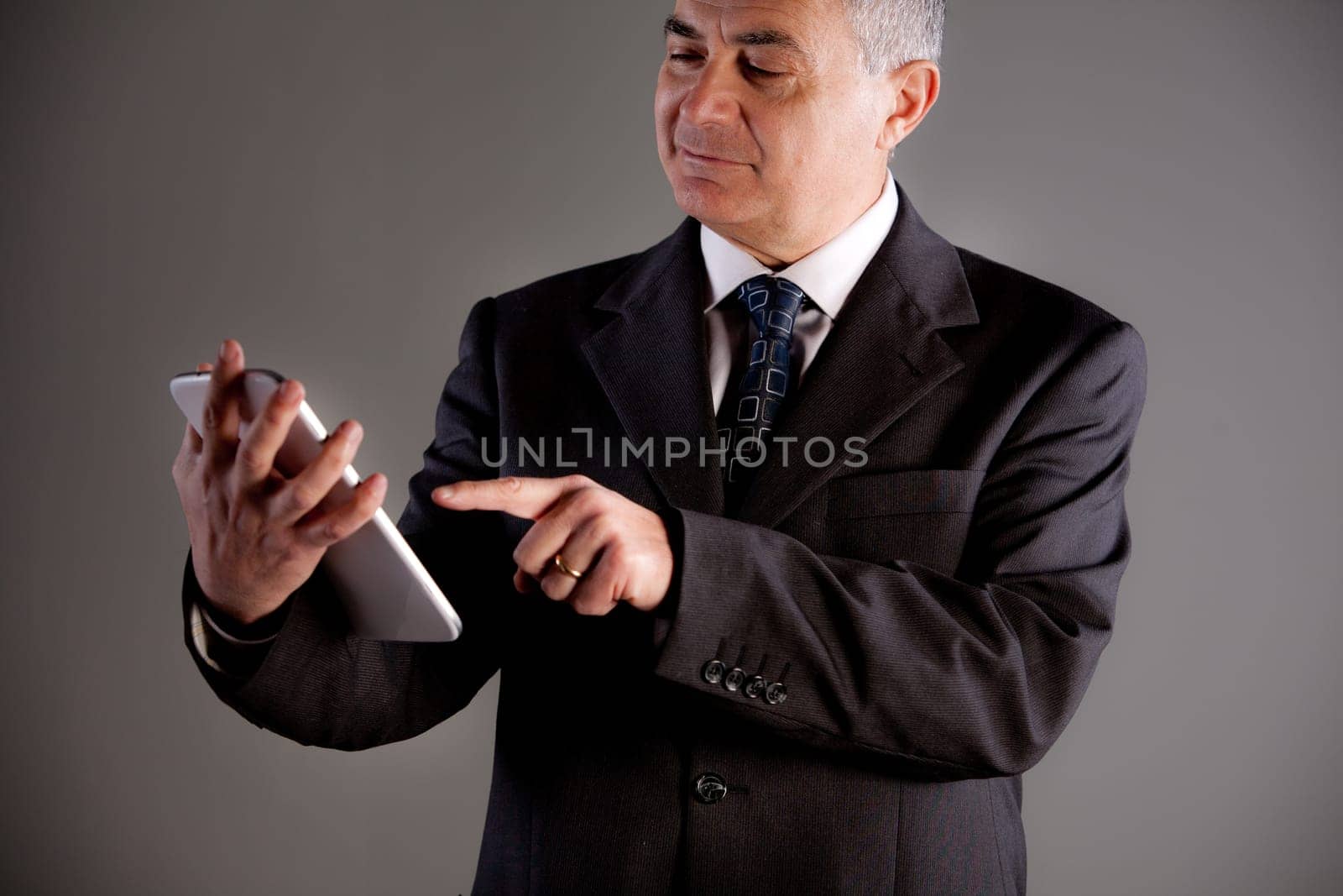An old manager using successfully and with satisfaction a tablet
