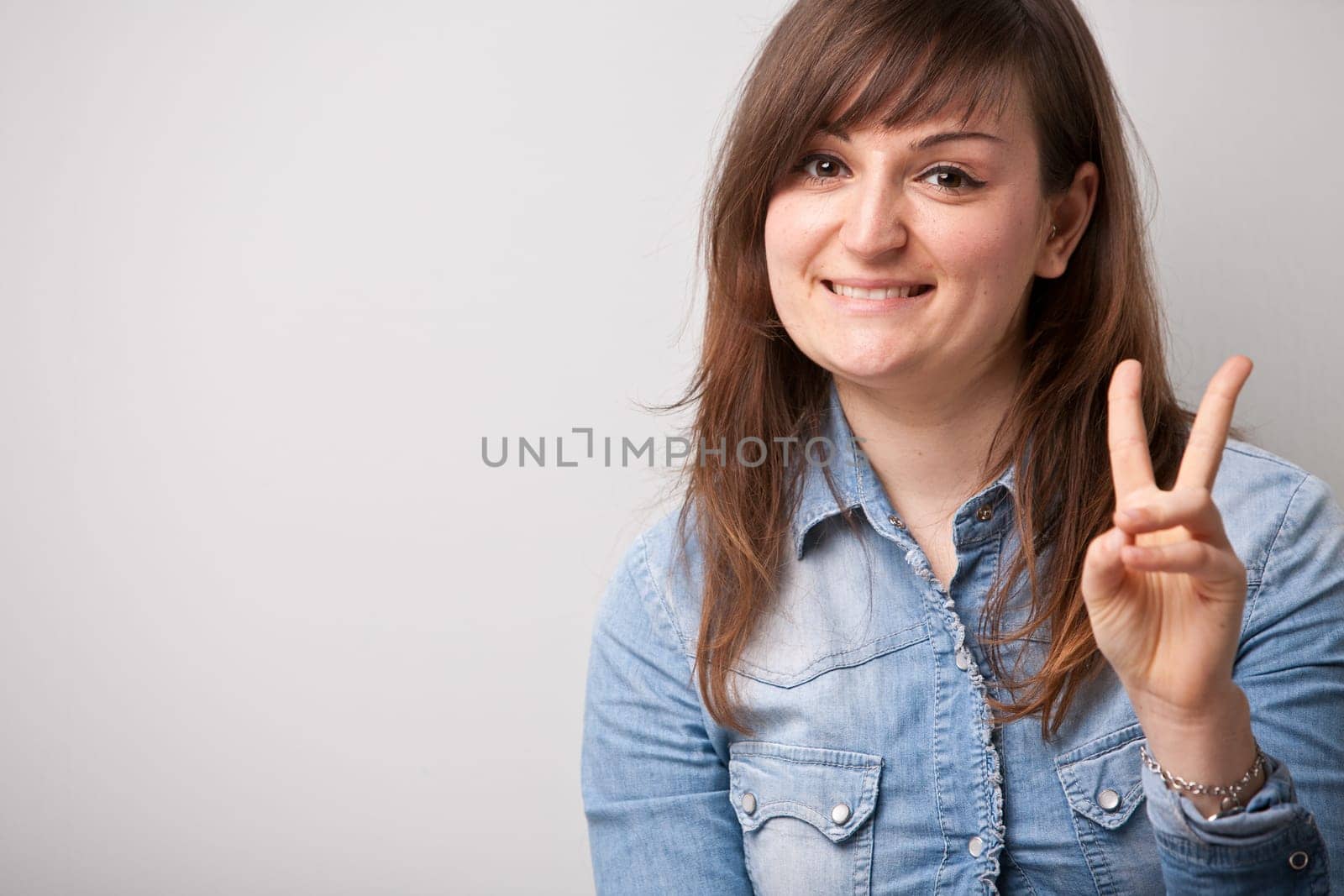 ordinary successful girl showing off fingers of victory