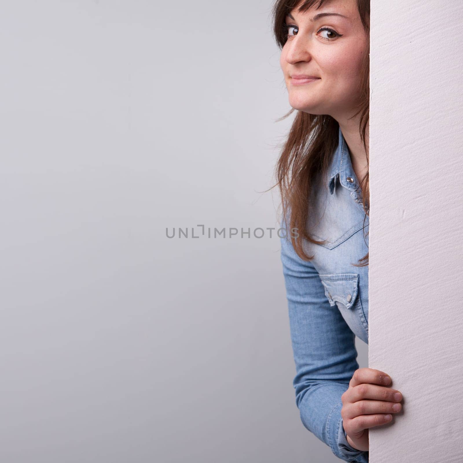 Nice girl showing up behind the white wall