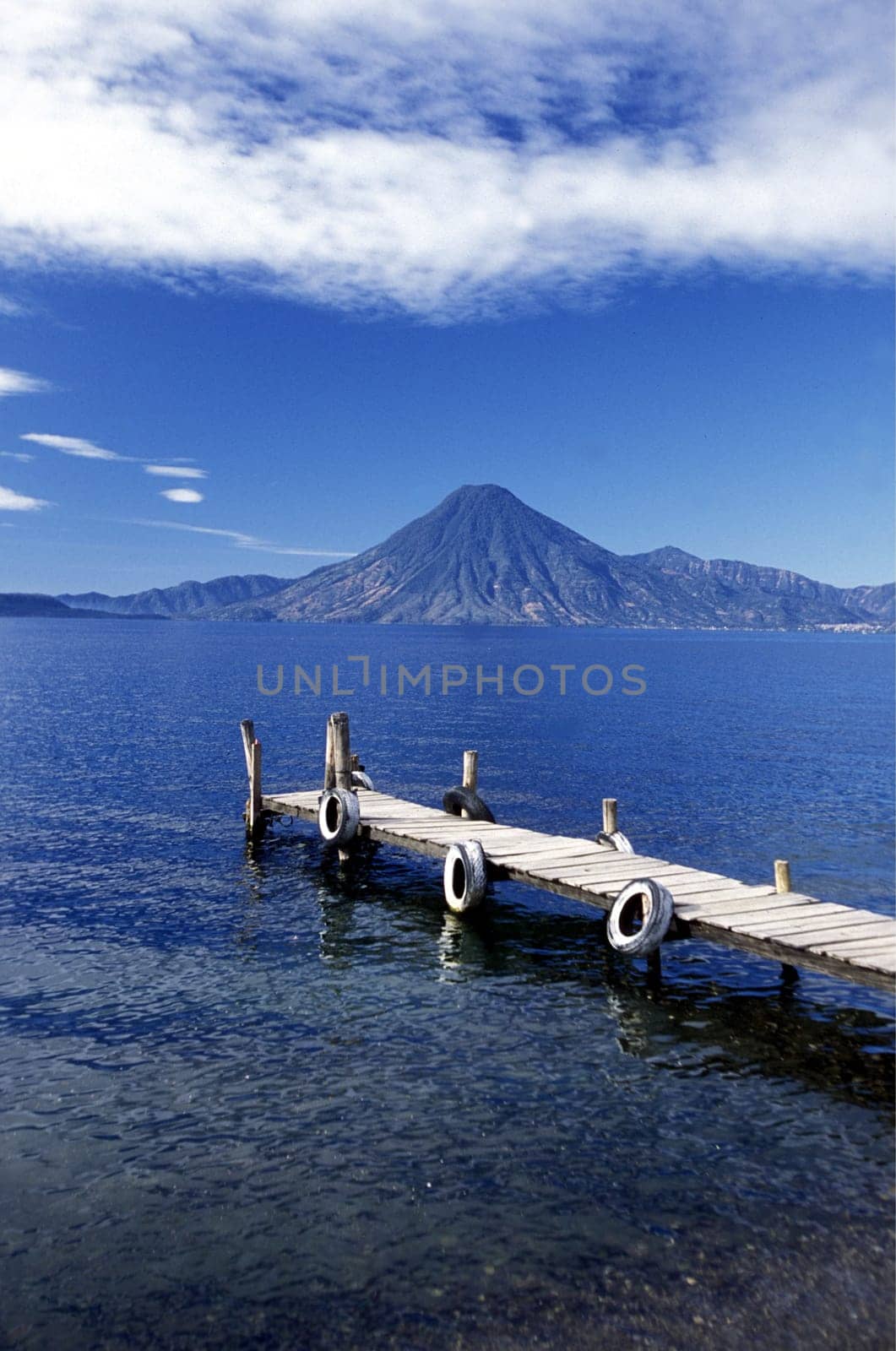The Lake Atitlan with the Volcanos of Toliman and San Pedro in the back at the Town of Panajachel in Guatemala in Central America.