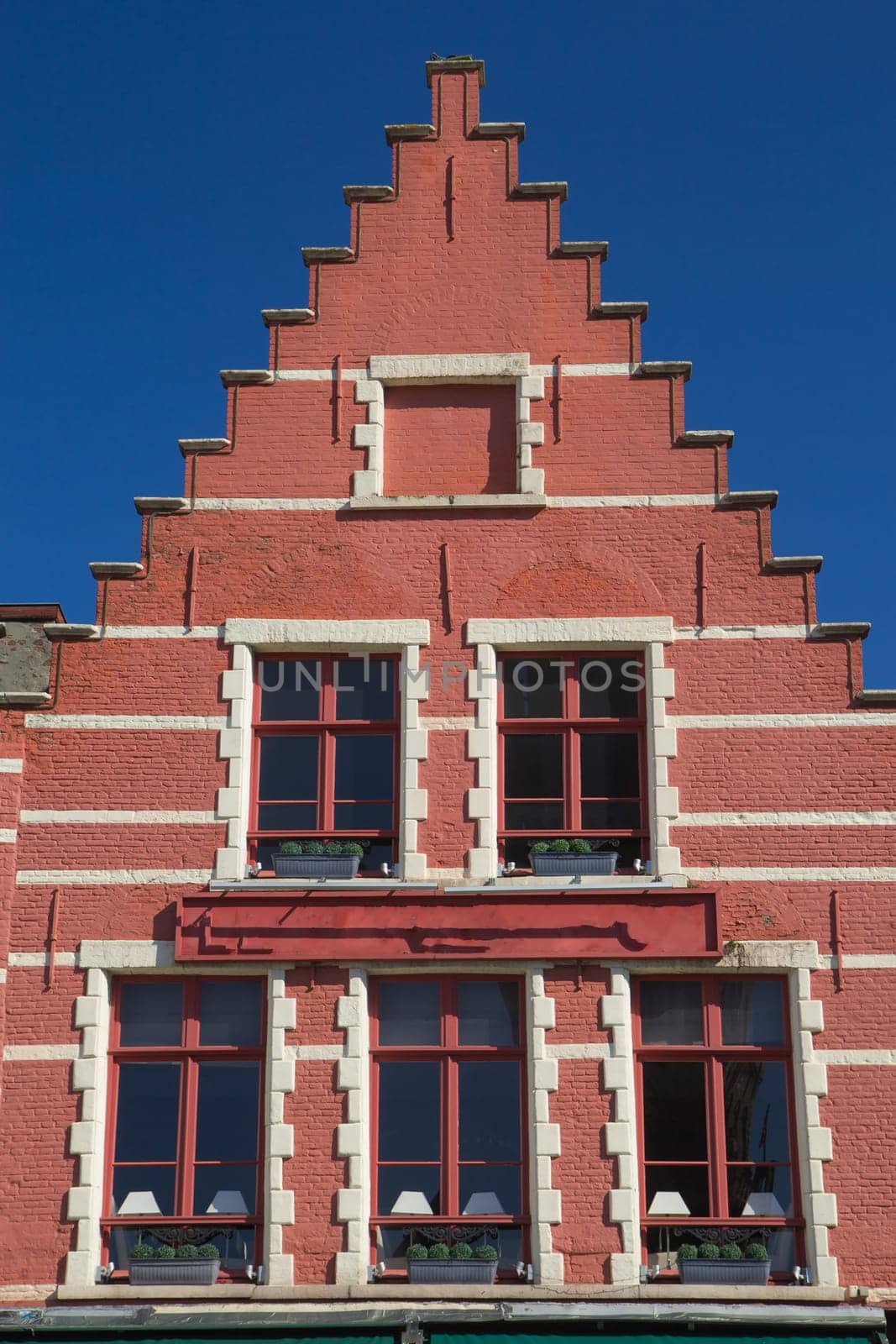 Red gable roof of the historic house (Bruges, Belgium). Front view.