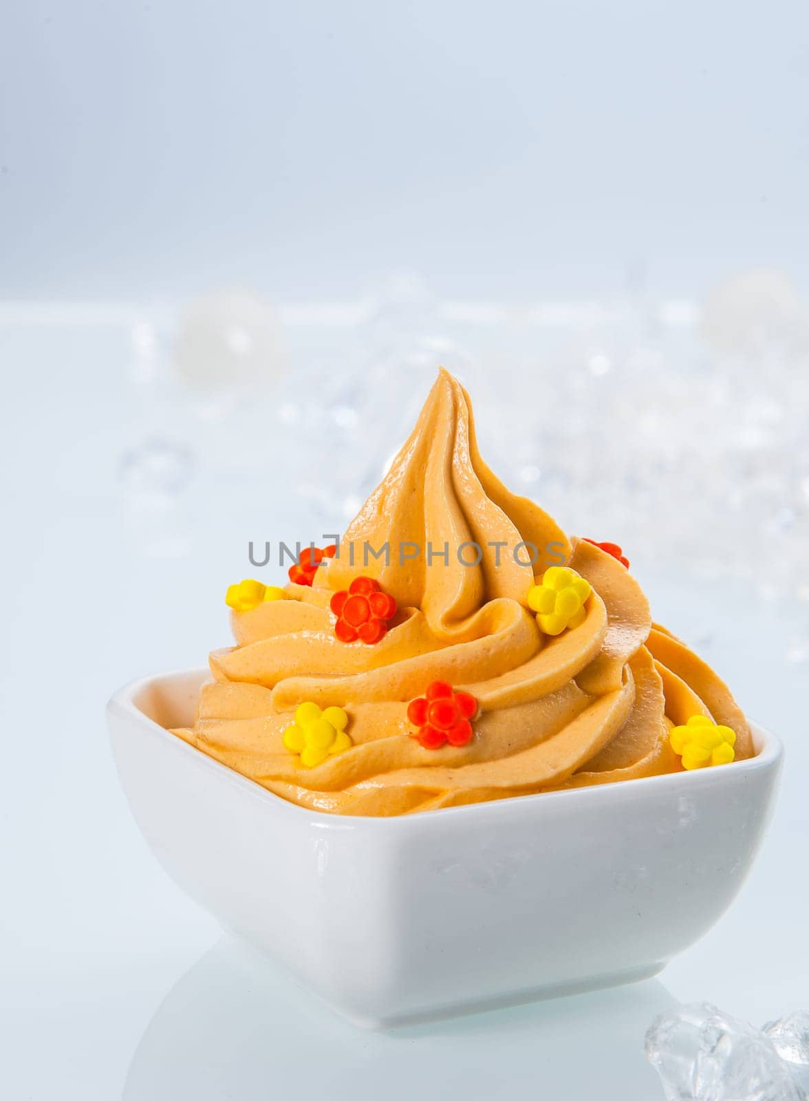 Close up Delicious Yellow Colored Frozen Yogurt on White Bowl Served on White Table.