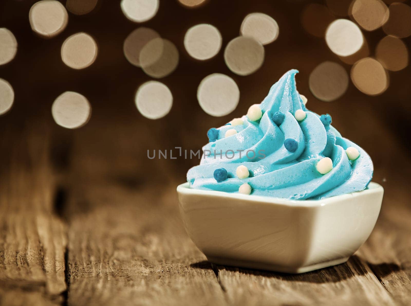 Tasty Sky Blue Frozen Yogurt on White Bowl with Toppings Placed on Wooden Table