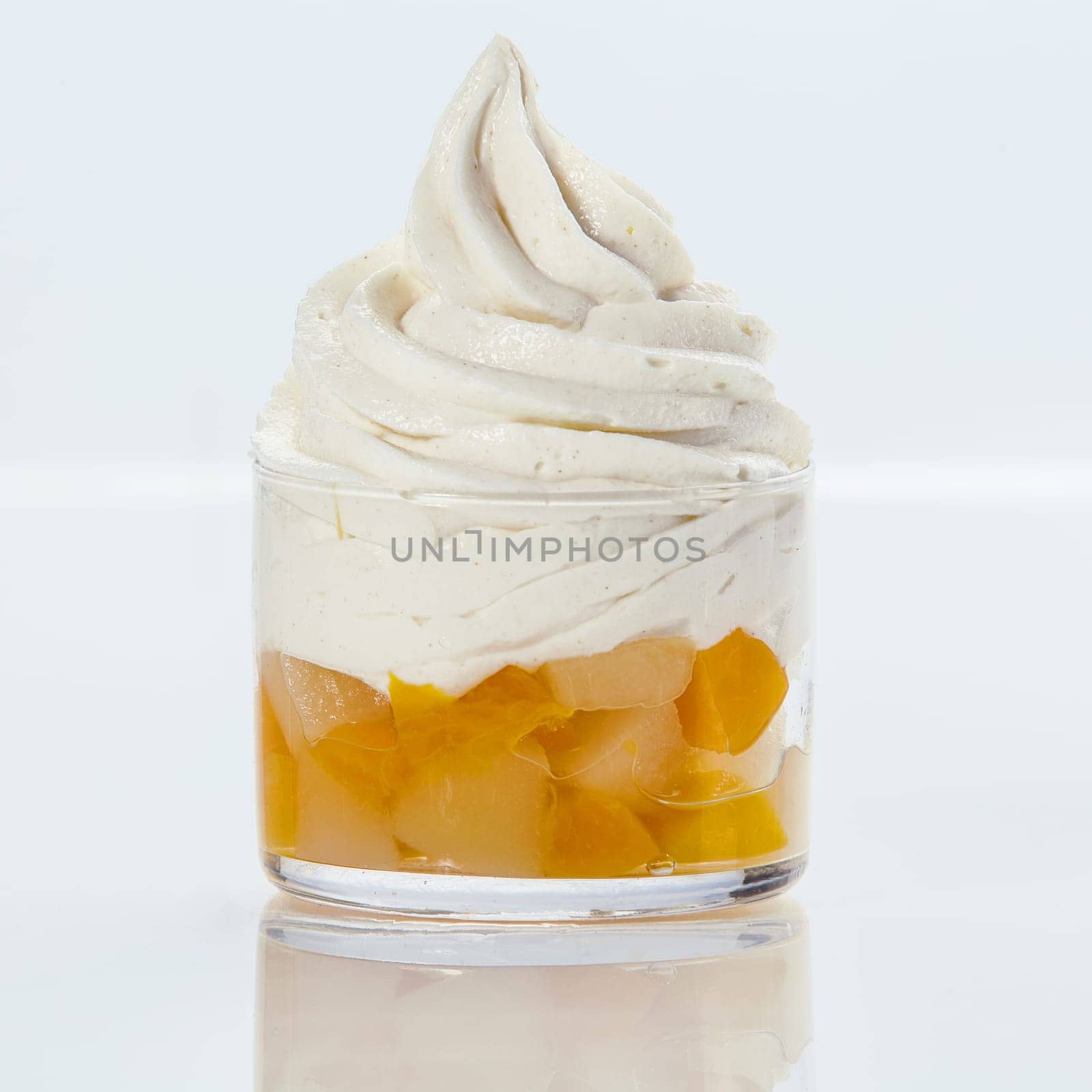 Delicious refreshing twirl of frozen yogurt with fresh fruit salad served in a glass dish on a white background , square format