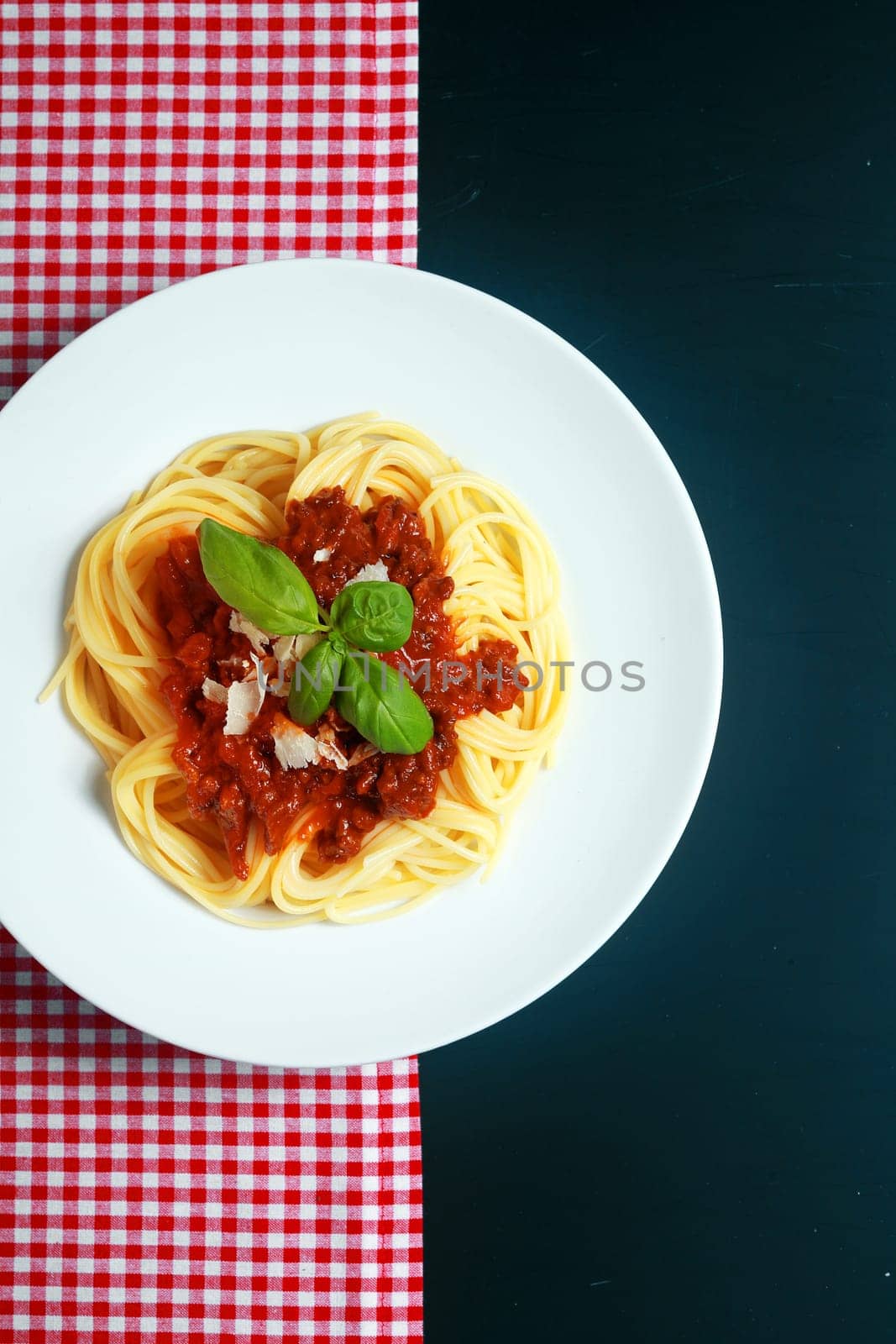 Plate of spaghetti Bolognaise or Bolognese with a rich tomato and ground beef sauce garnished with basil and parmesan cheese