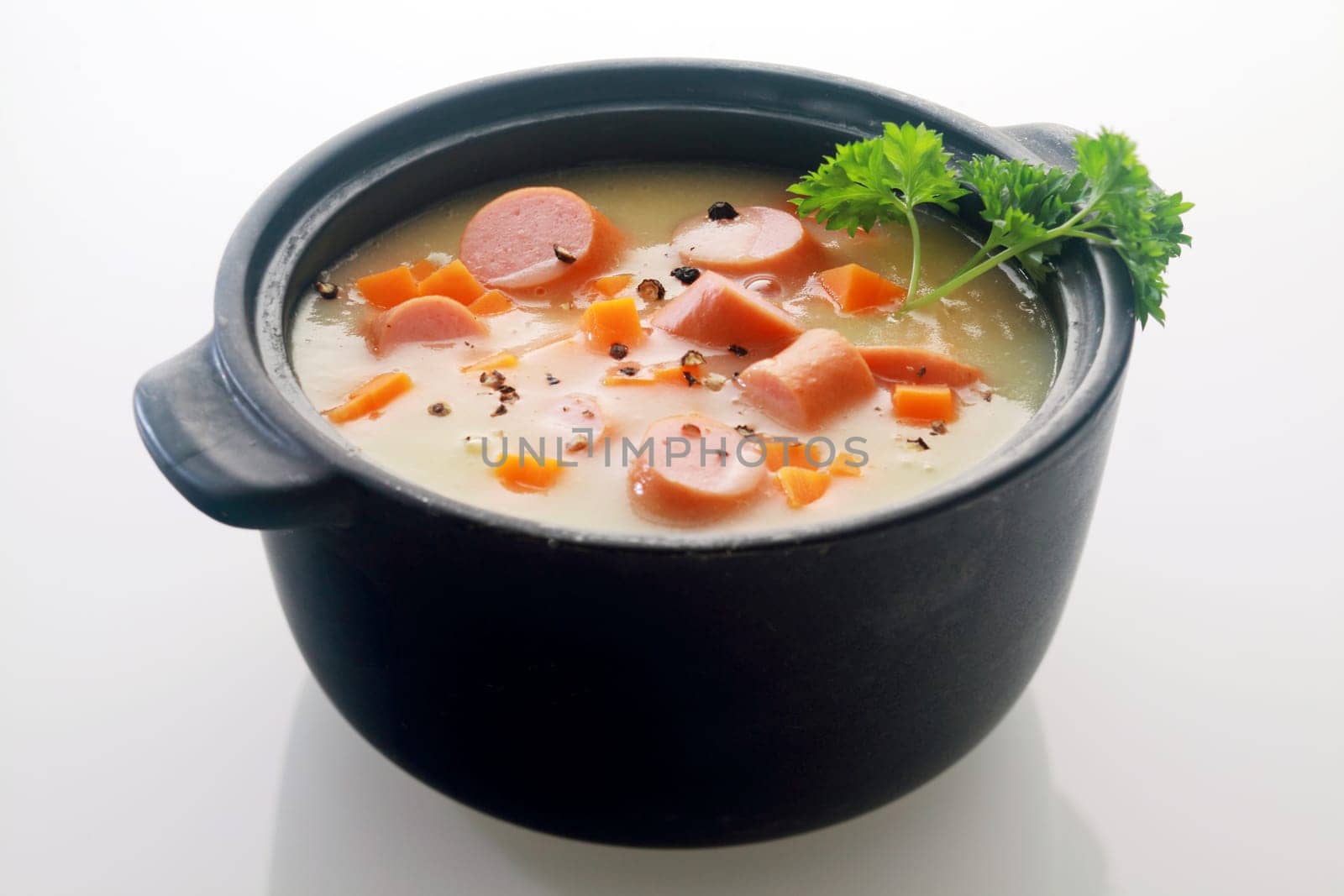 Appetizing Main Course Soup Dish Recipe on Black Pot Isolated on Gray Background.