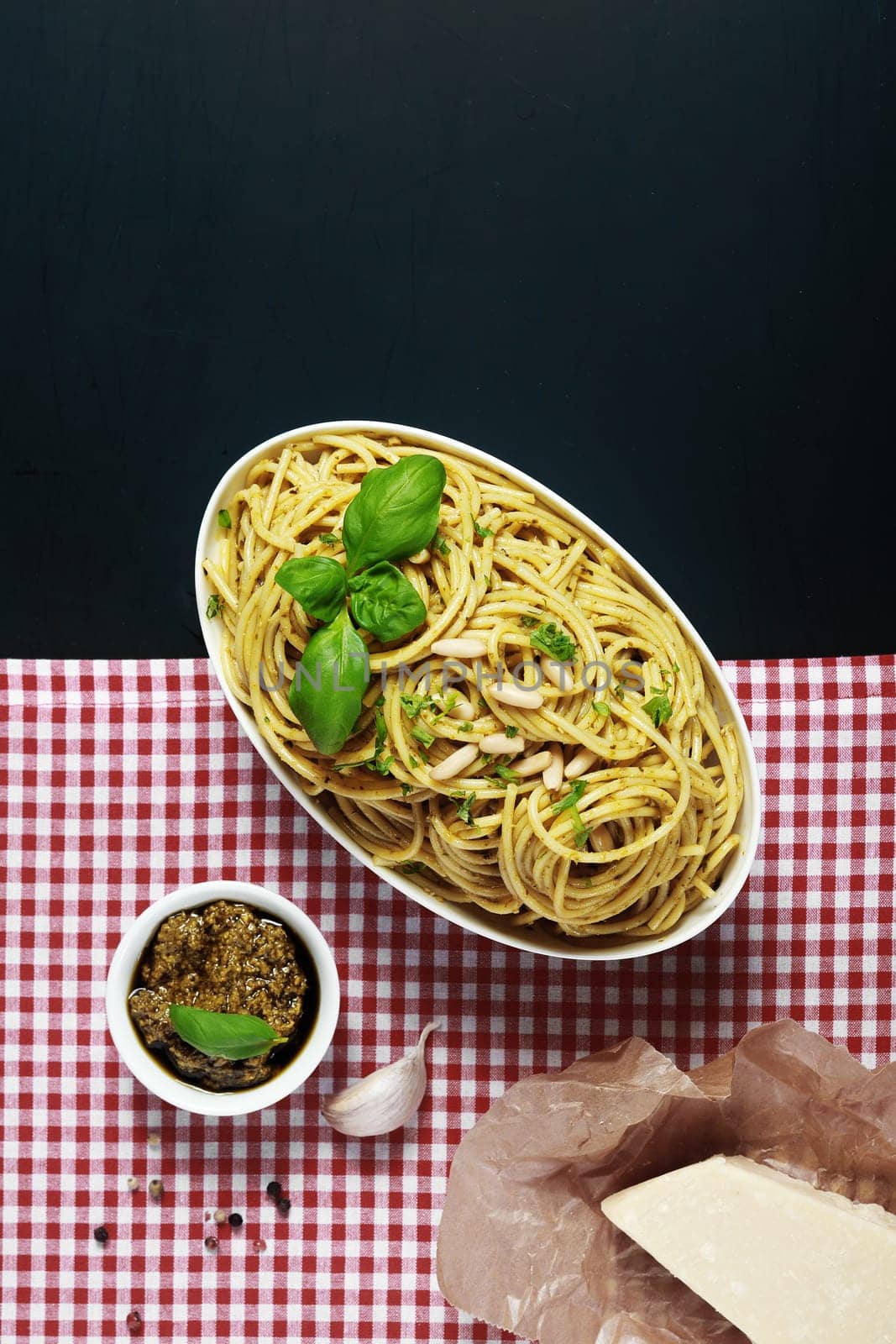 Appetizing Italian Recipes on Red and White Checkered and Black Background. Emphasizing the Mouth Watering Pasta on White Bowl.