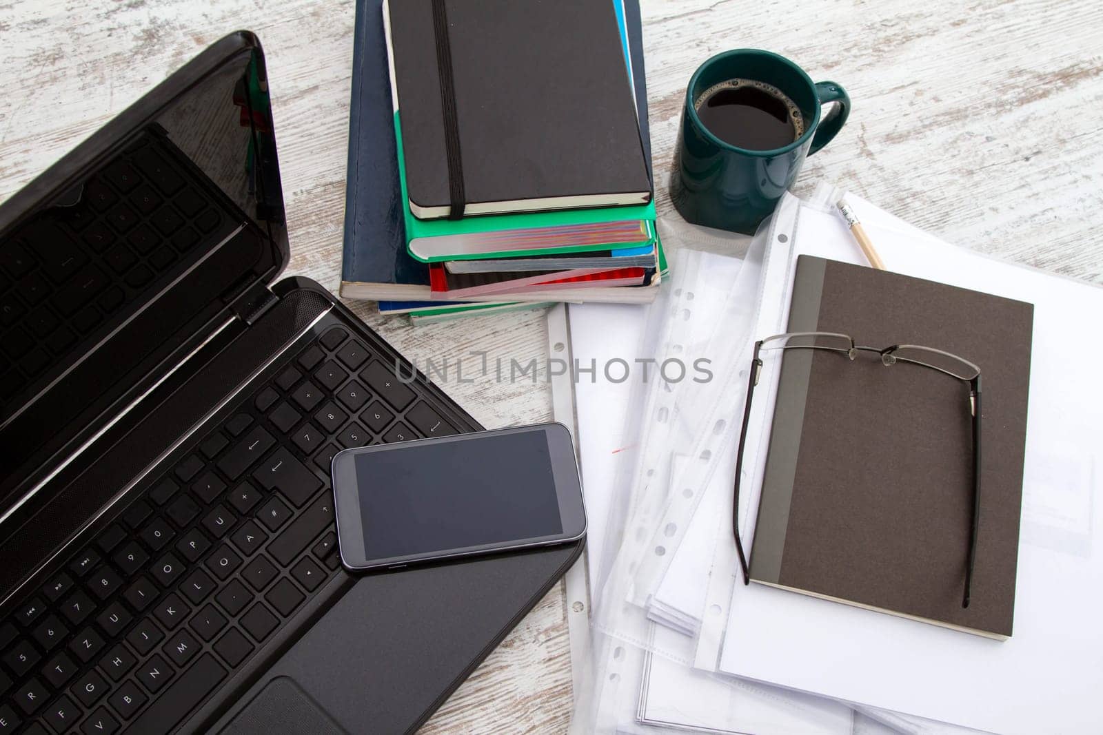 Working, with the laptop, a pile of books, and drinking a coffee.