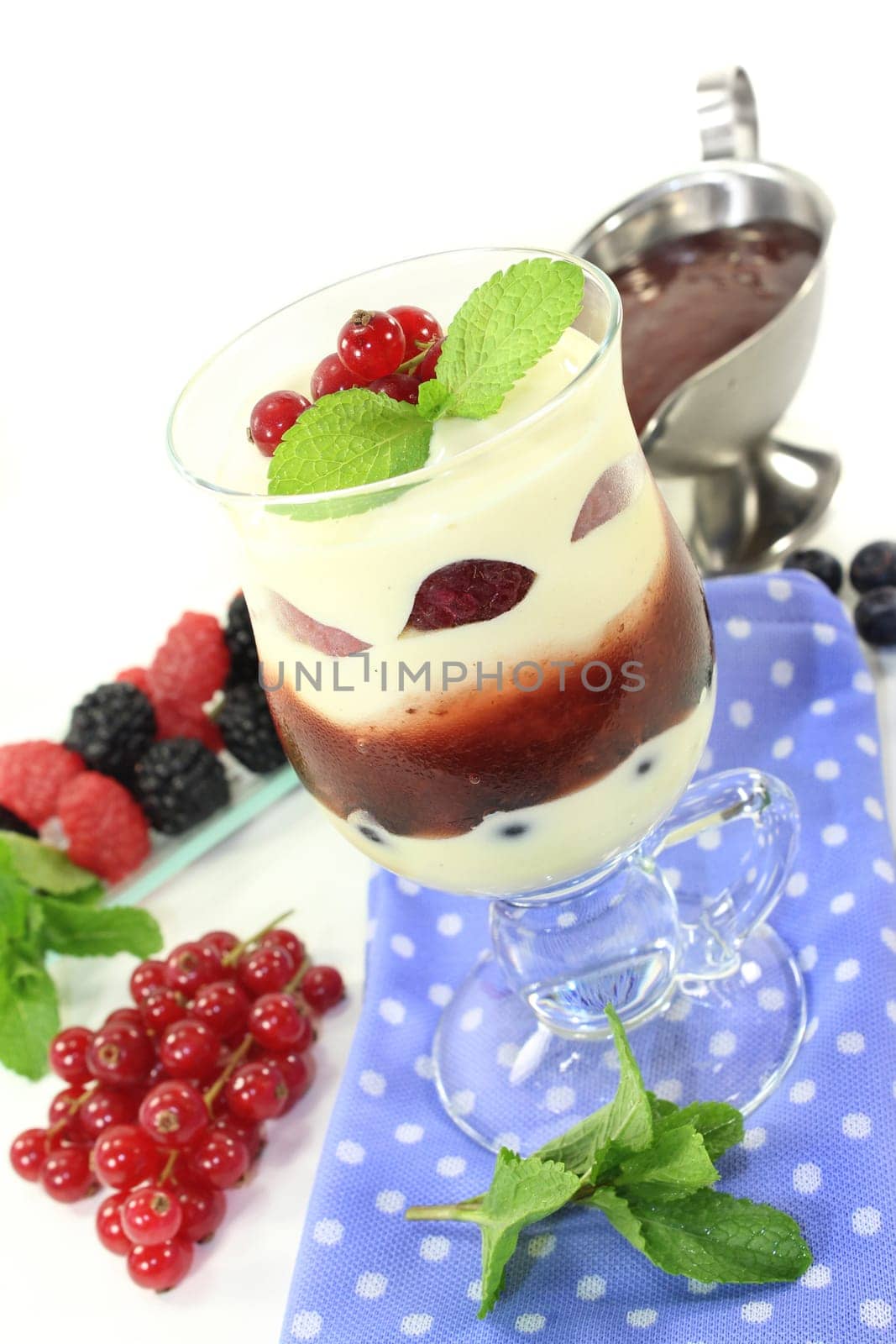 a dessert in a glass,layered with pudding,red grits and berries