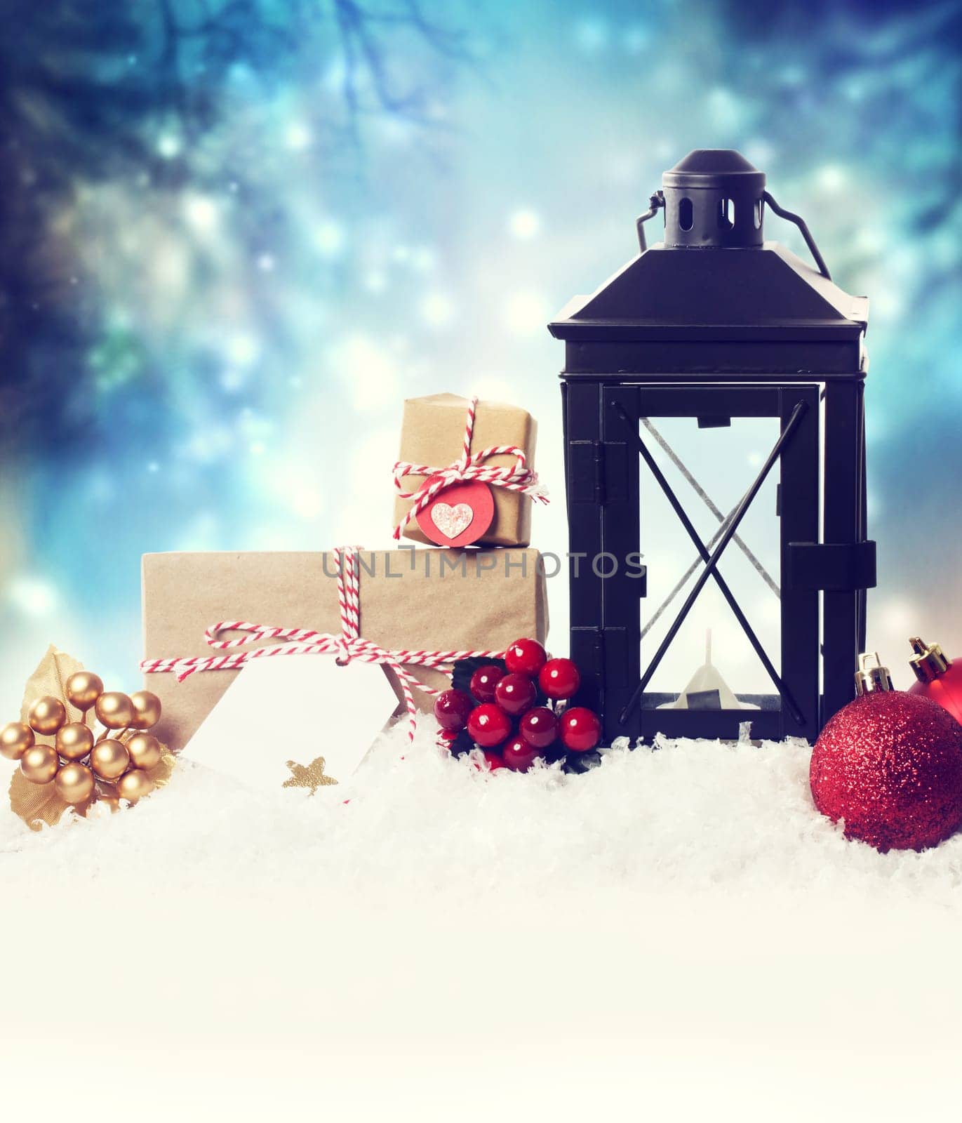 Christmas lantern with ornaments in the snow at night