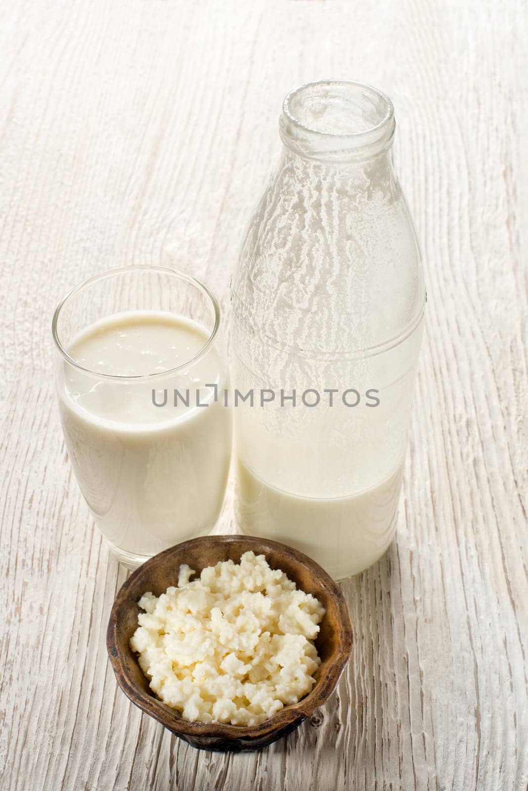 Milk kefir and grains in glass on wooden table