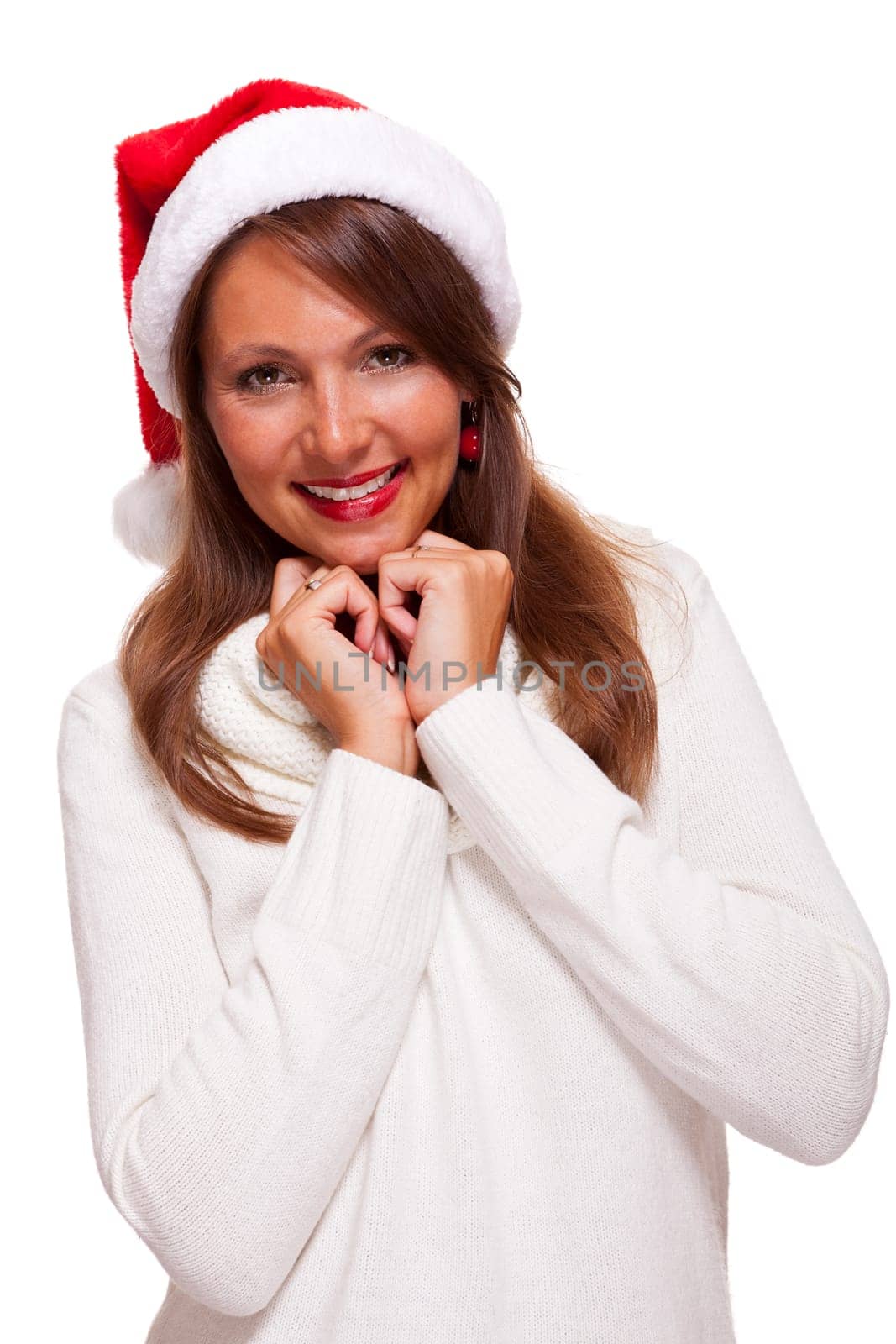 Attractive woman wears a festive red Christmas hat and cuddles up in a turtleneck sweater with a charming friendly smile,isolated on white