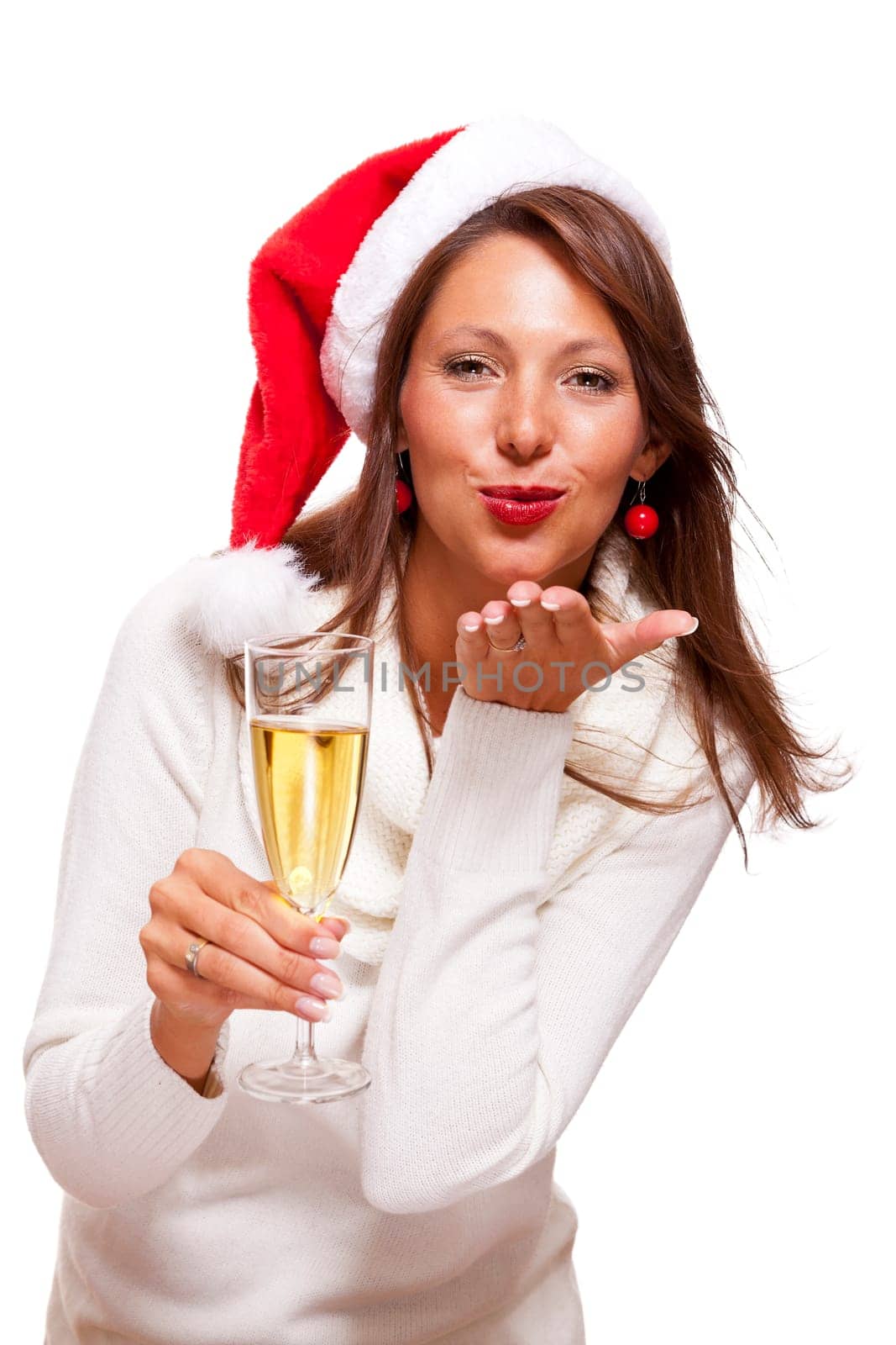Attractive woman with red Santa hat holds a glass of champagne in her hand and smiles isolated on white background freeing text space