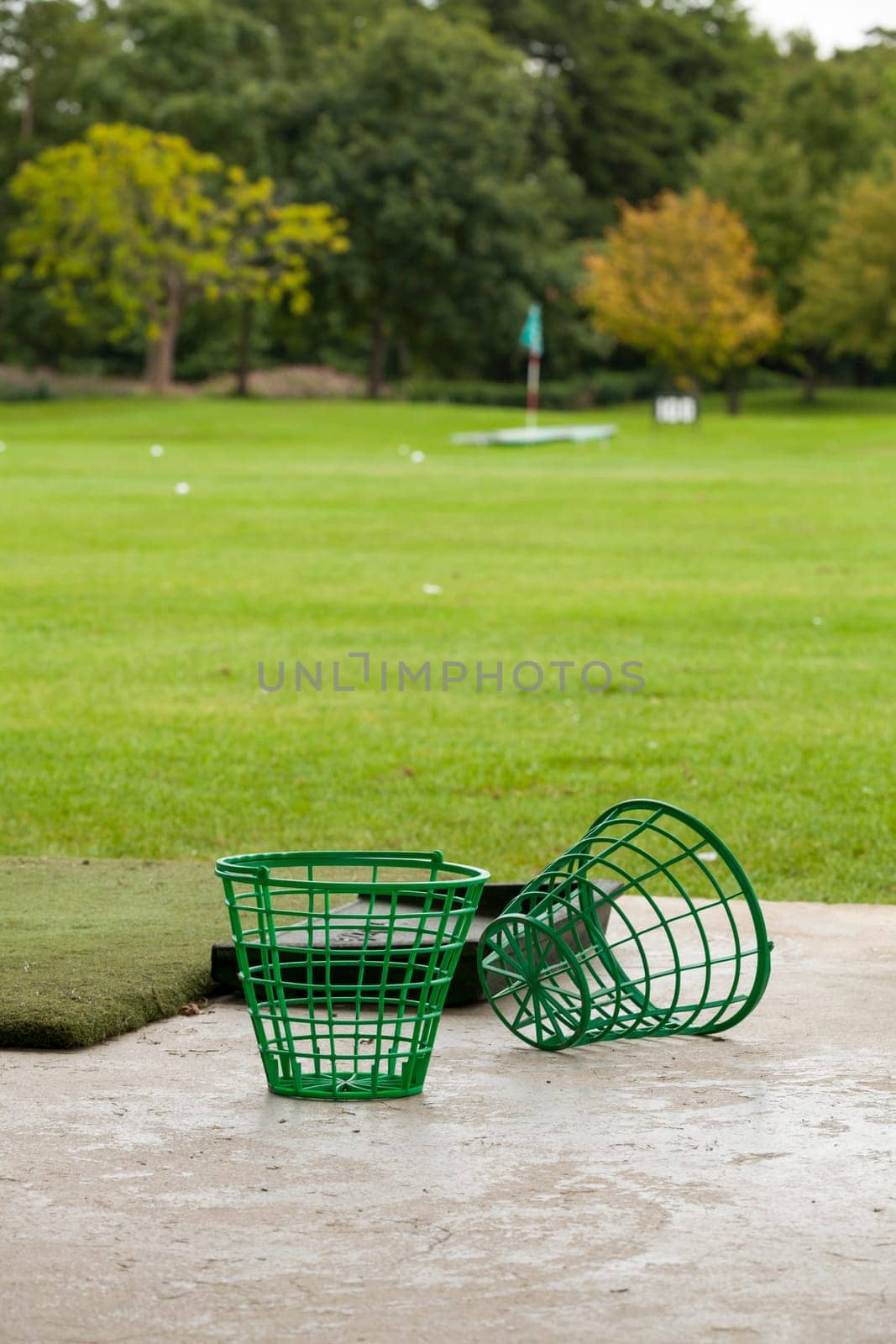Driving range with golf balls and tee at a golf course in summer outdoors