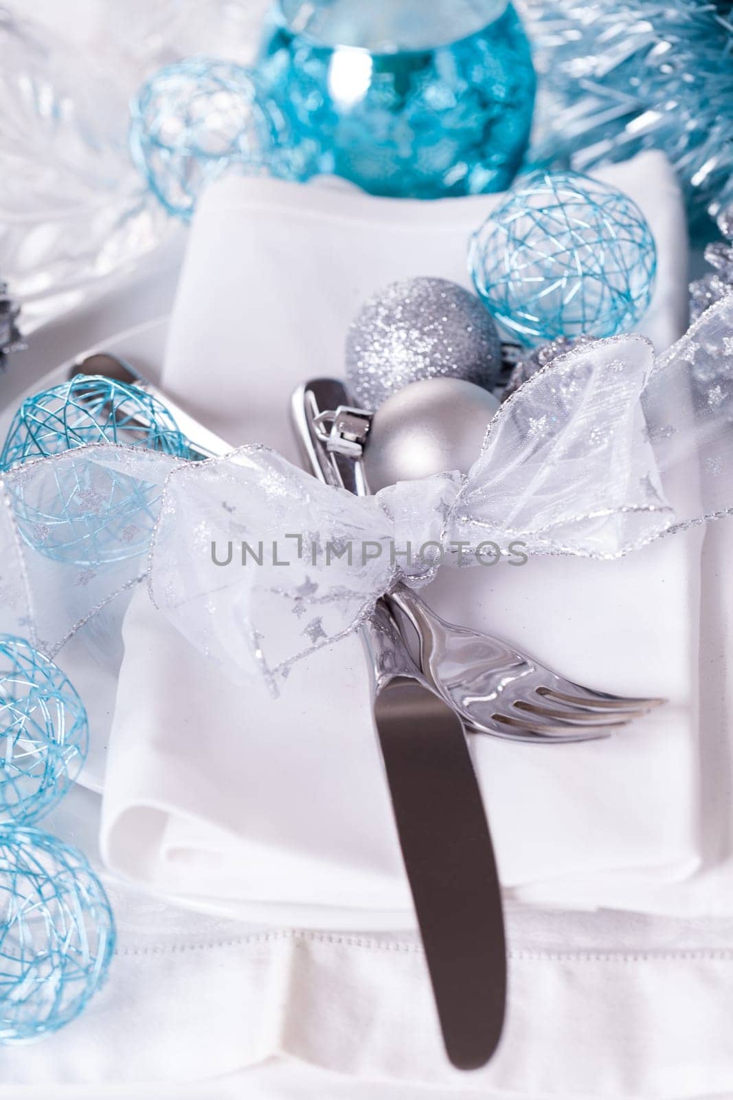Stylish table with Christmas decoration in turquoise and silver shiny with cutlery