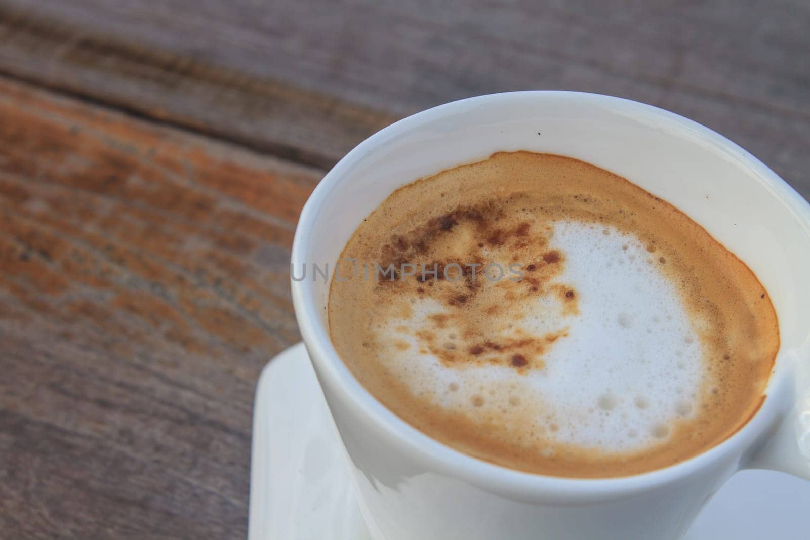 Cup of cappuccino coffee on wooden table