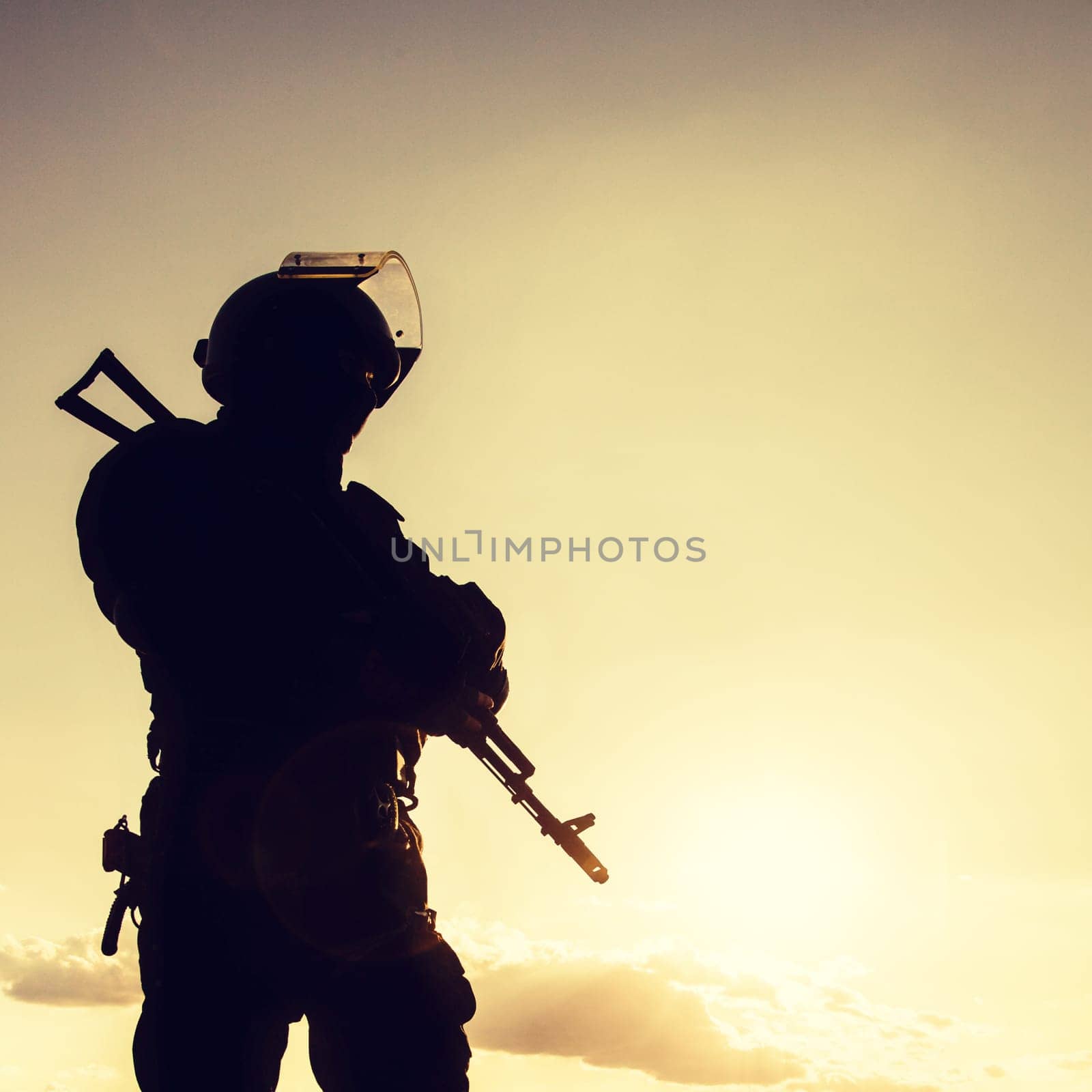 Silhouette of police officer with weapons at sunset