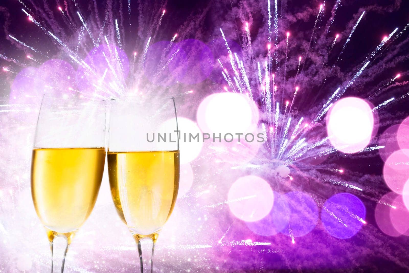 Glasses with champagne against holiday lights and clock close to midnight