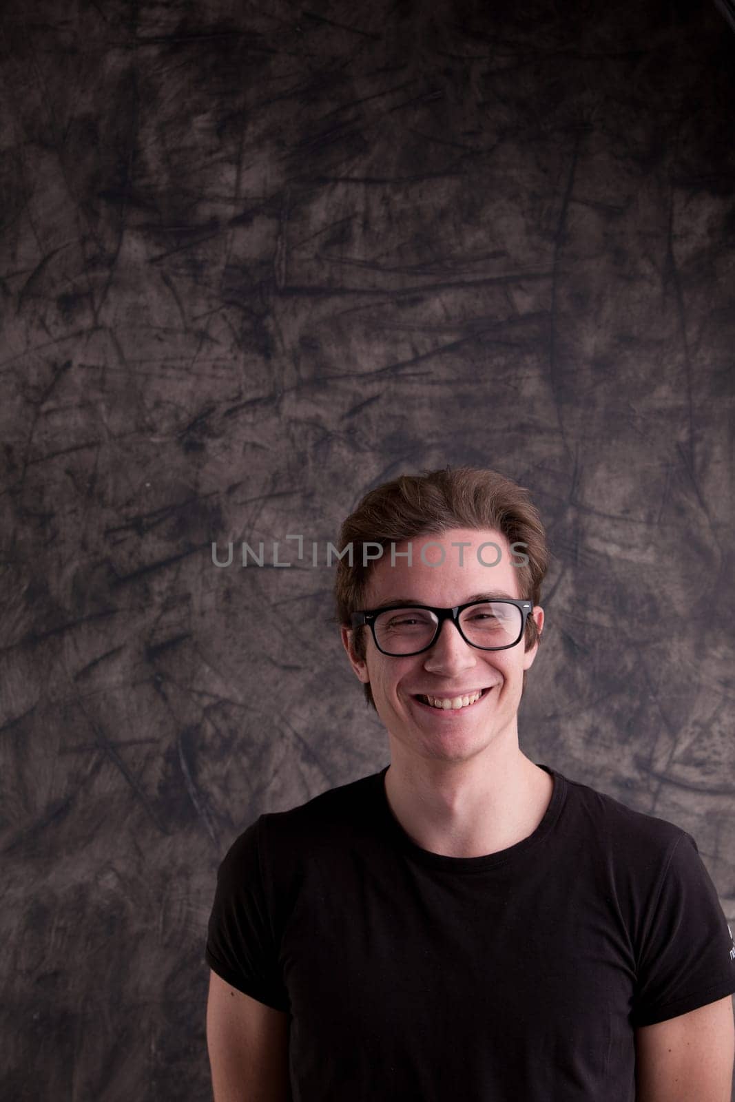 nerdy guy smiling at us in front of a blackboard