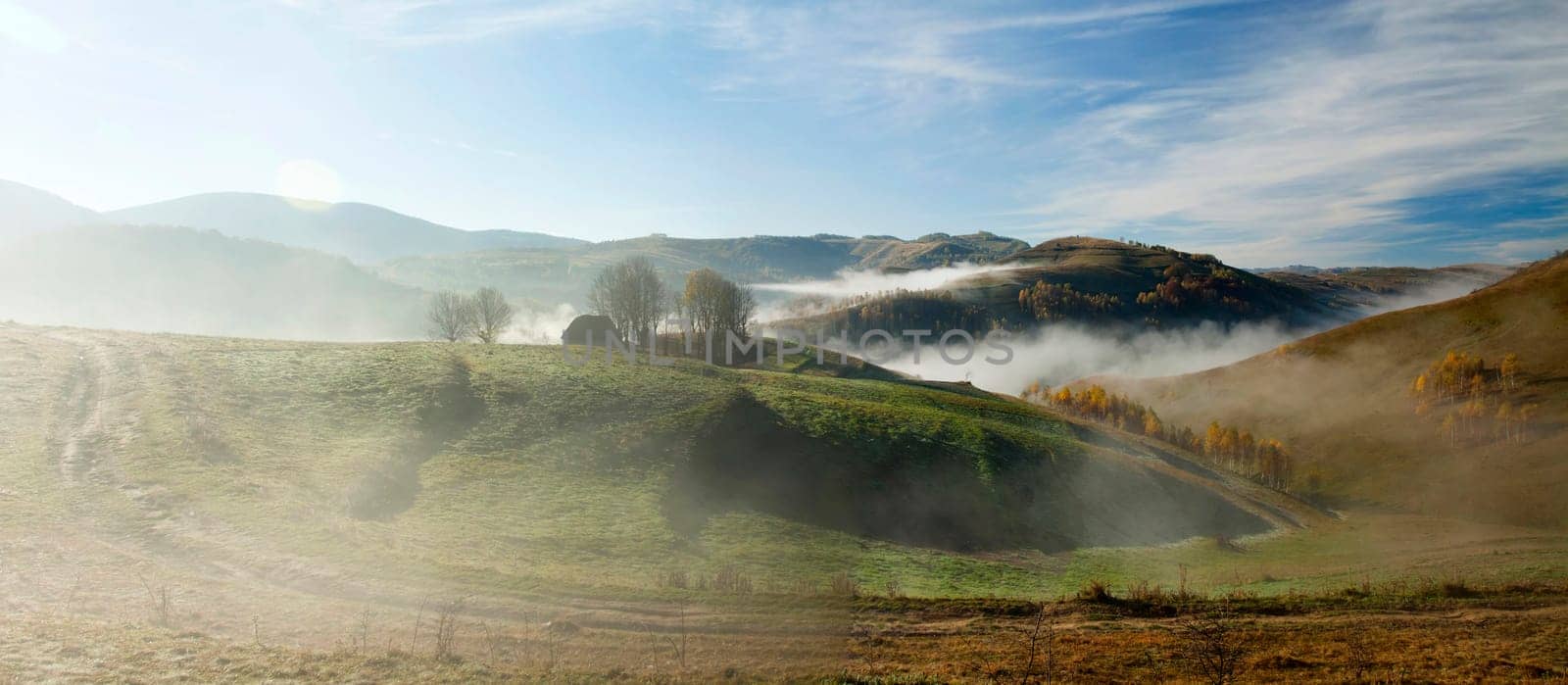 Panoramic view of  Small cottage in the mountains in a foggy autumn morning