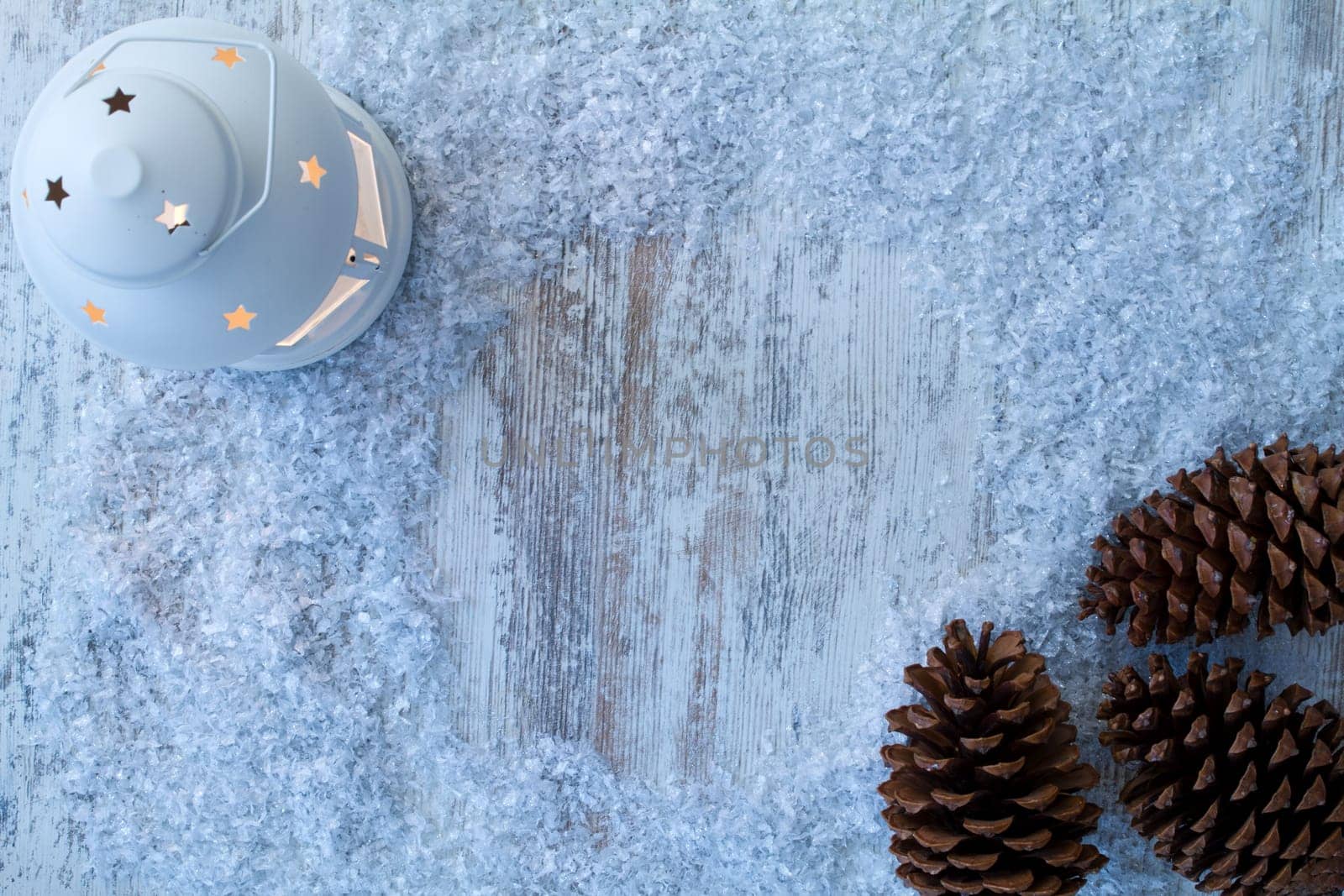 Wooden Christmas background with candle and pine cones..