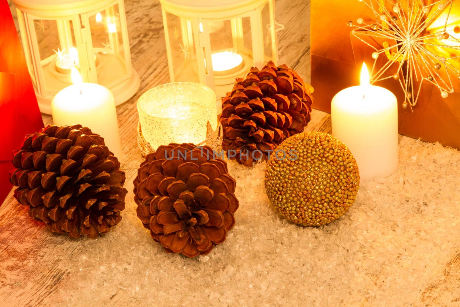 Christmas setting with candles, pine cones, shopping bags and baubles..
