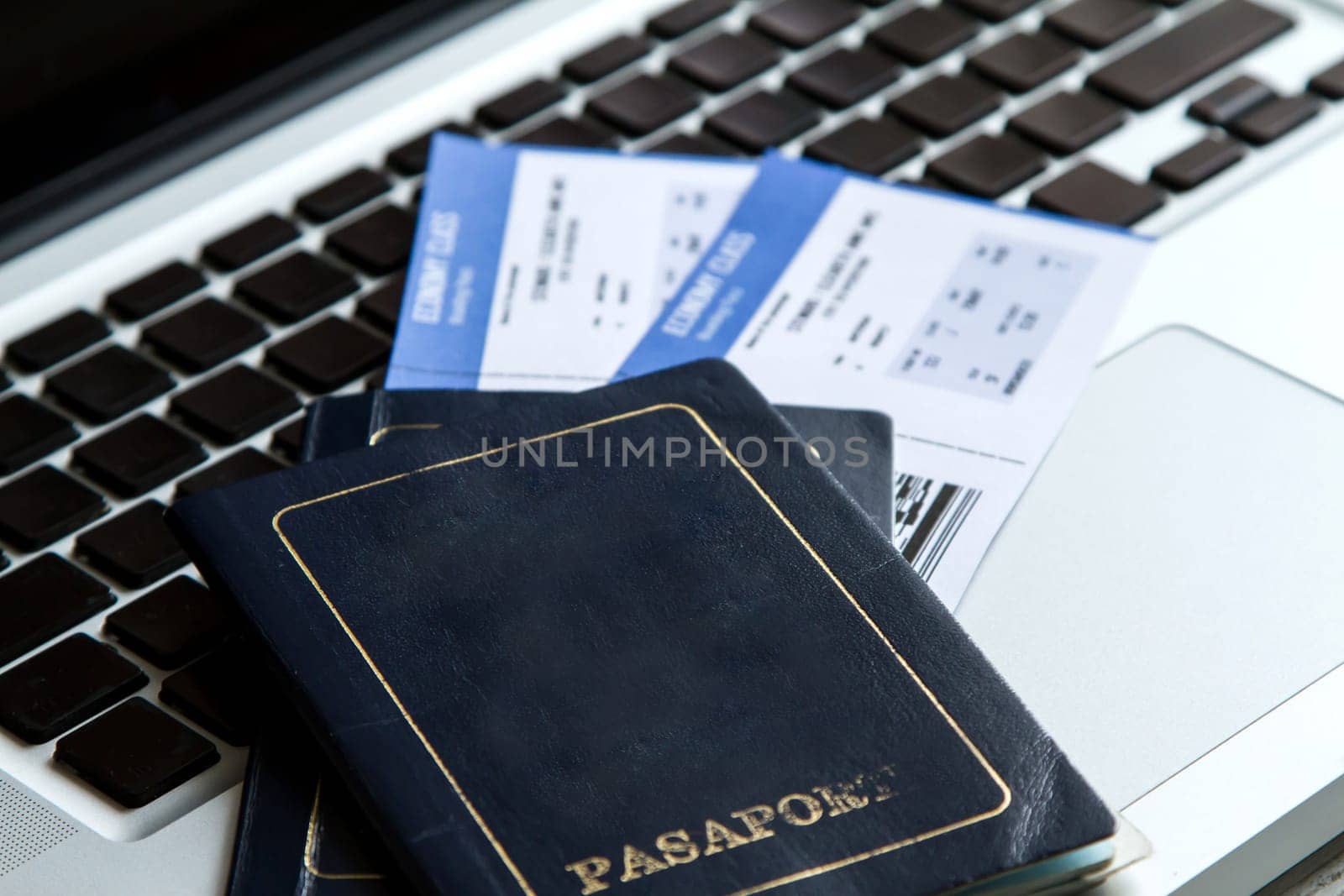 Airline tickets over the keyboard of a laptop.