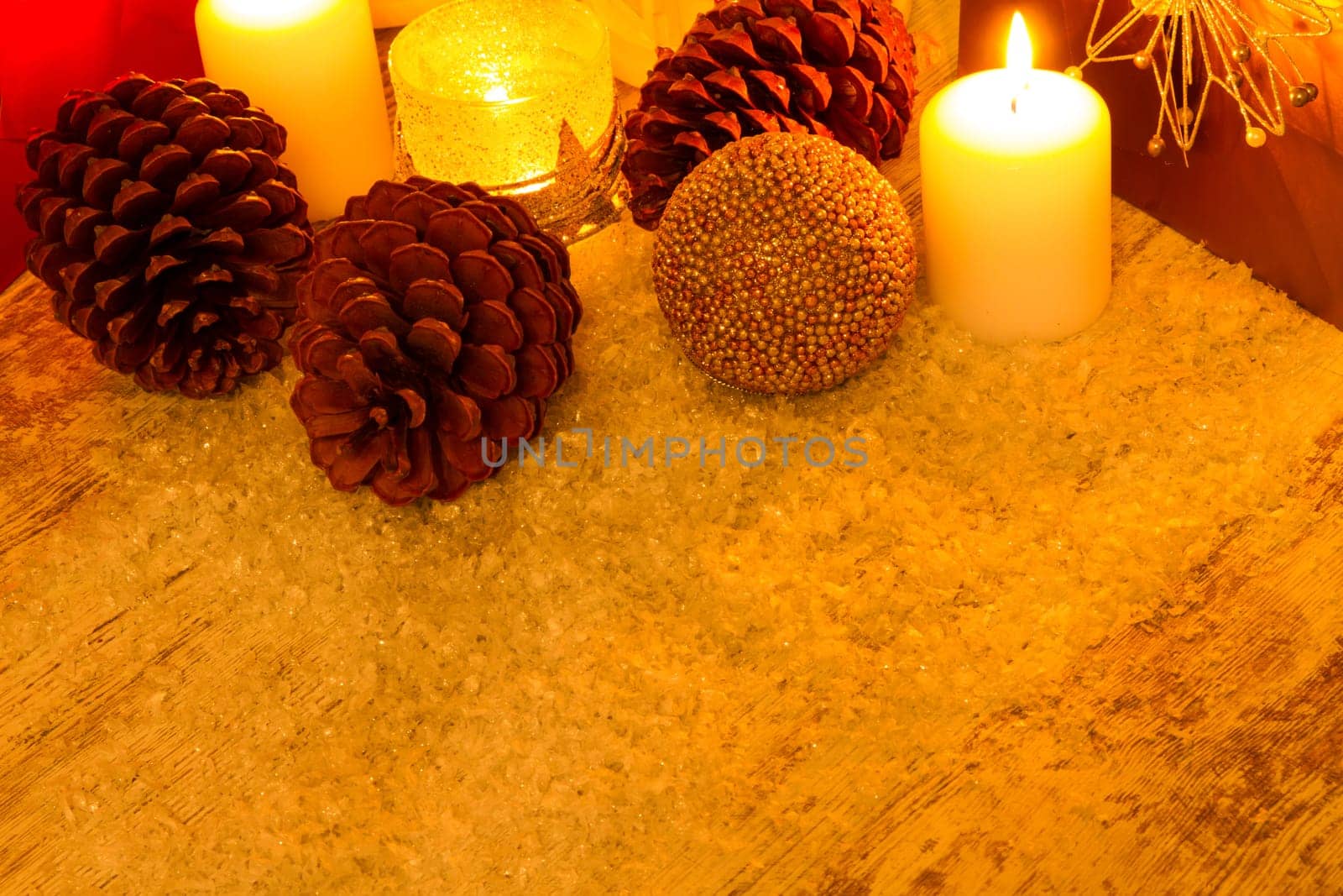 Wooden Christmas background with candles, pine cones, shopping bags and baubles..