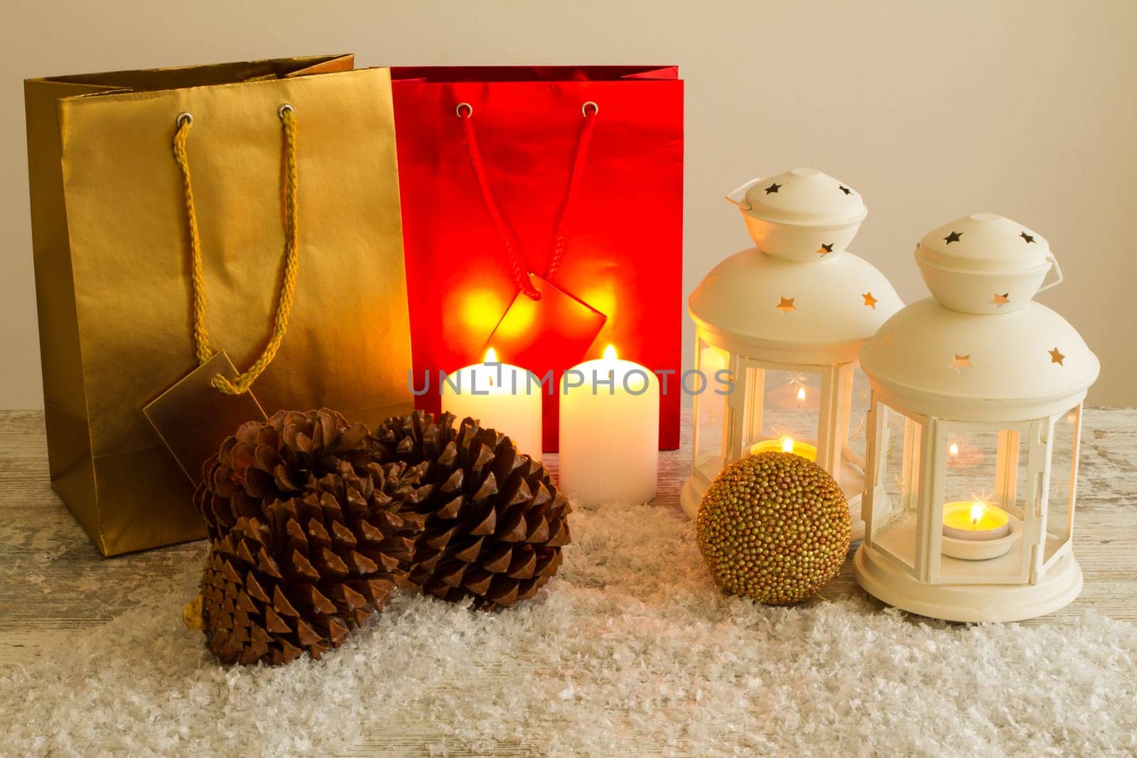 Christmas setting with candles, pine cones, shopping bags and baubles..