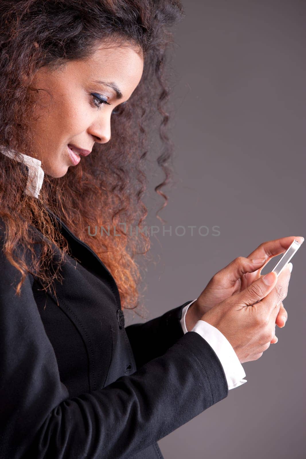 this brazilian or beaufitul afro-american curly girl is watching her mobile