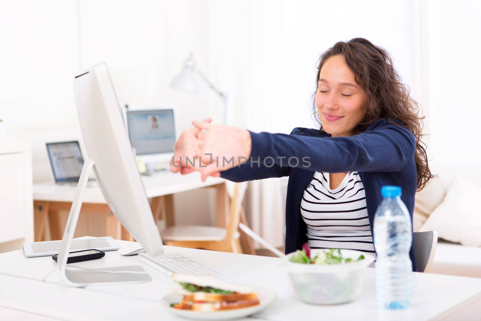 View of a Young attractive woman stretching during a meal break