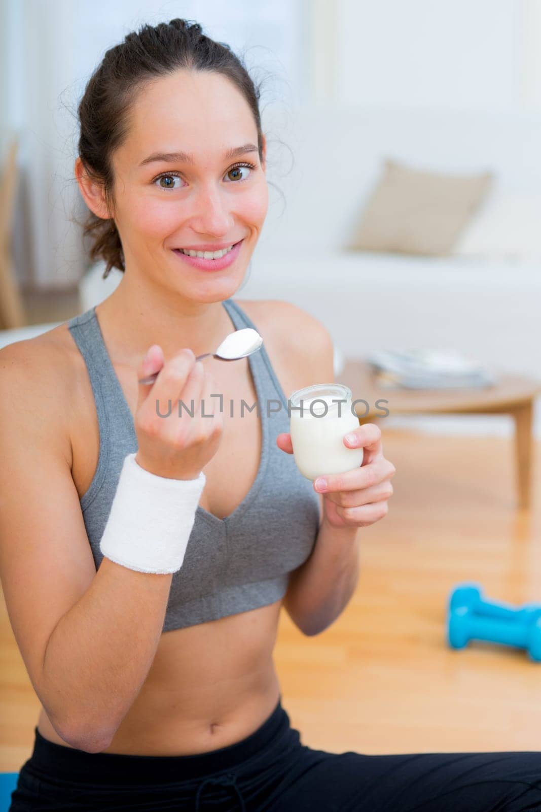 View of a Attractive sportive woman eating yoghurt after sport