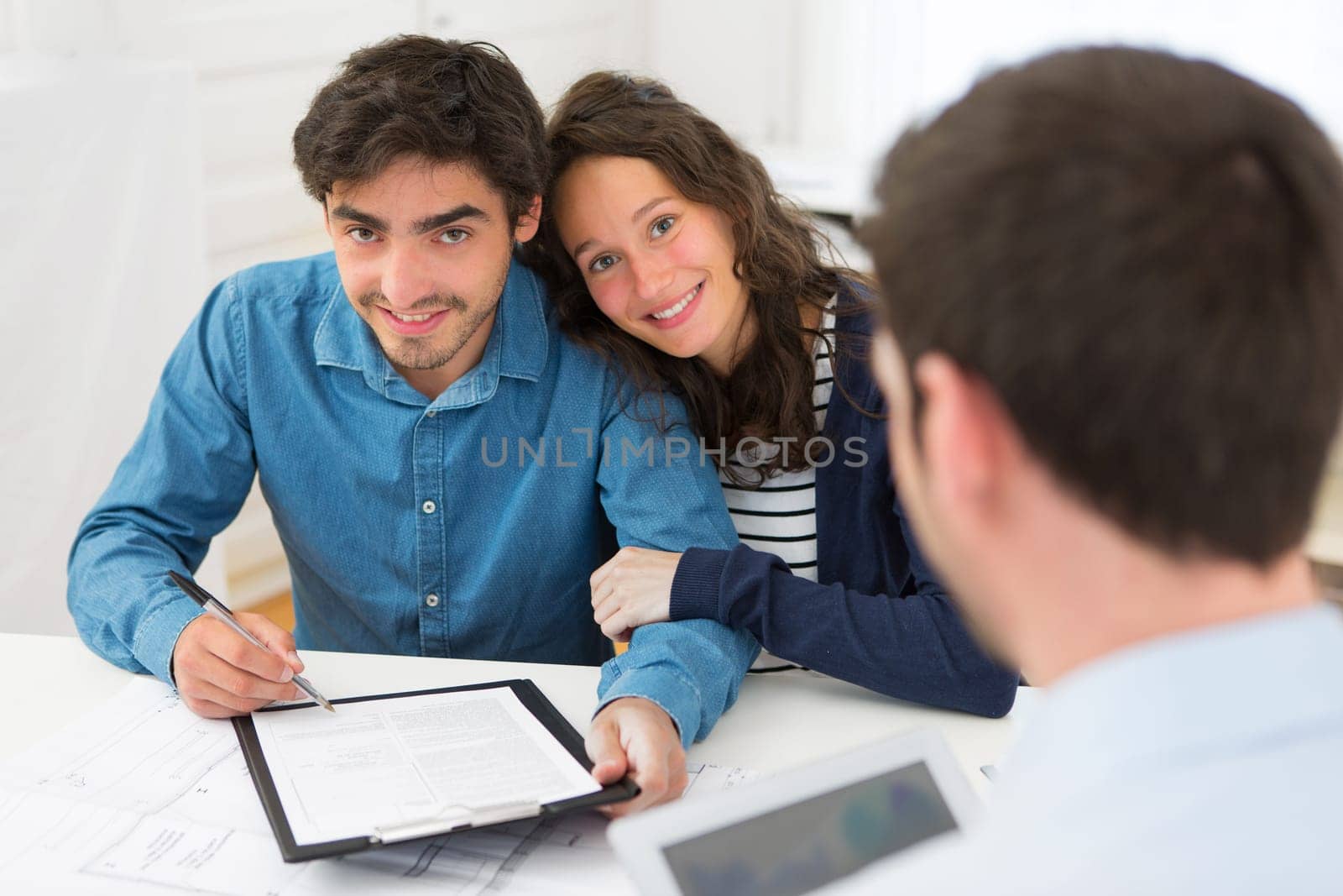 View of a Young attractive couple signing contract