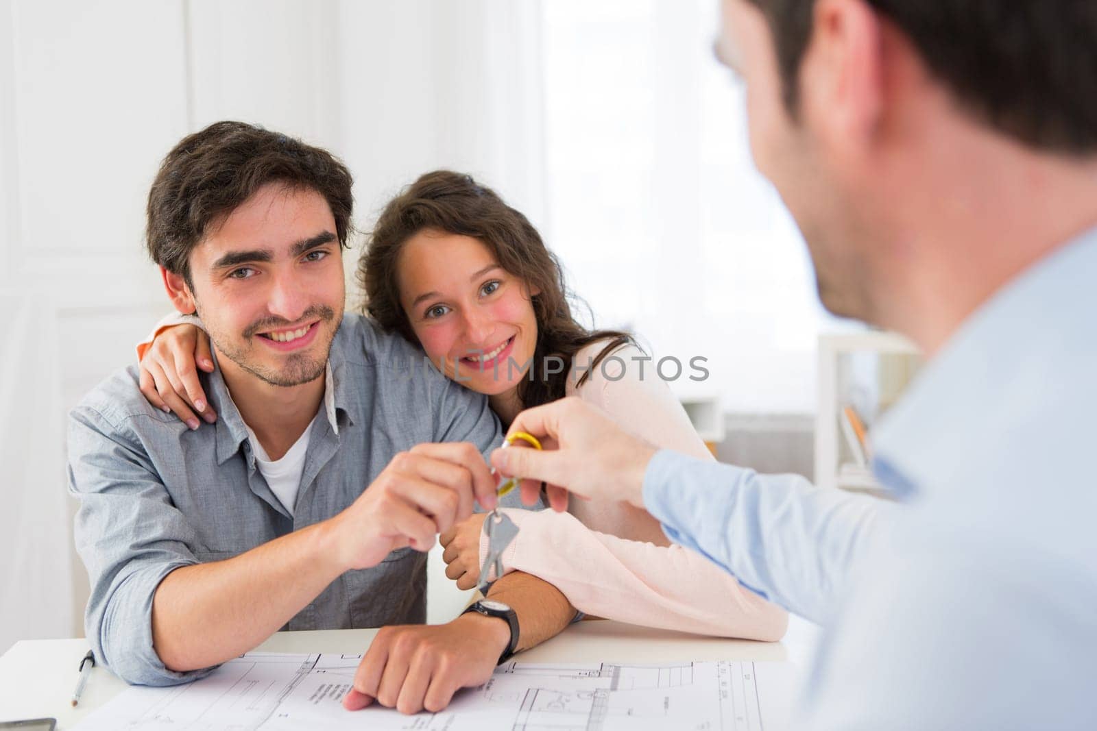 View of a Real estate handing over keys to couple