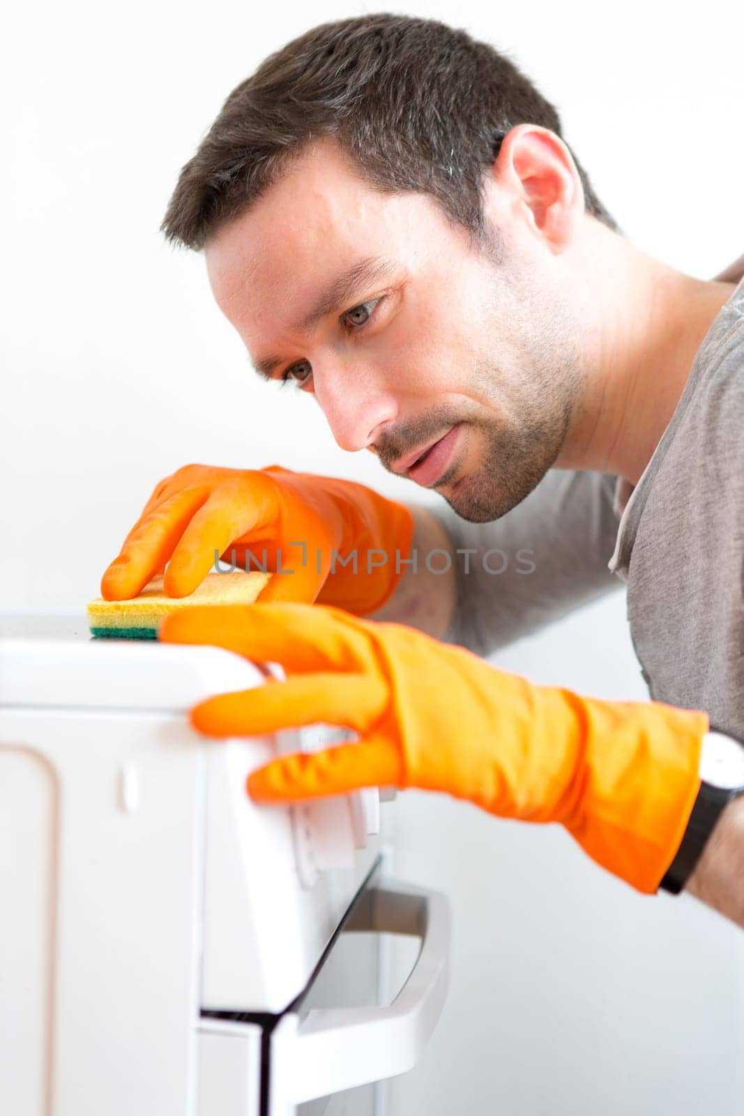 View of a Young attractive man cleaning his flat